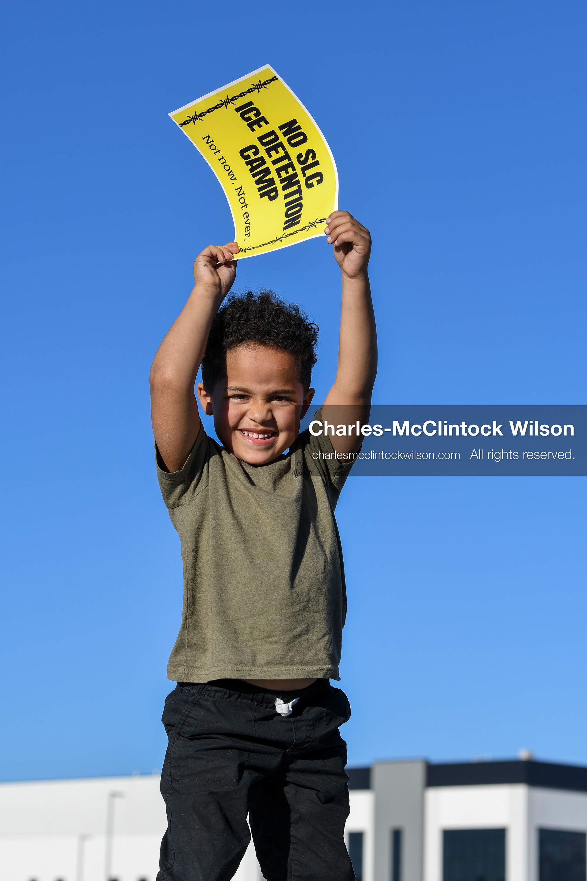 March 18, 2026, Salt Lake City, Utah, USA: A child holds a sign during a protest at the site of a proposed ICE detention facility on the west side of Salt Lake City. Demonstrators gathered at the warehouse property after federal officials confirmed the location was being considered for future detention operations. (Credit Image: © Charles McClintock Wilson/ZUMA Press Wire)