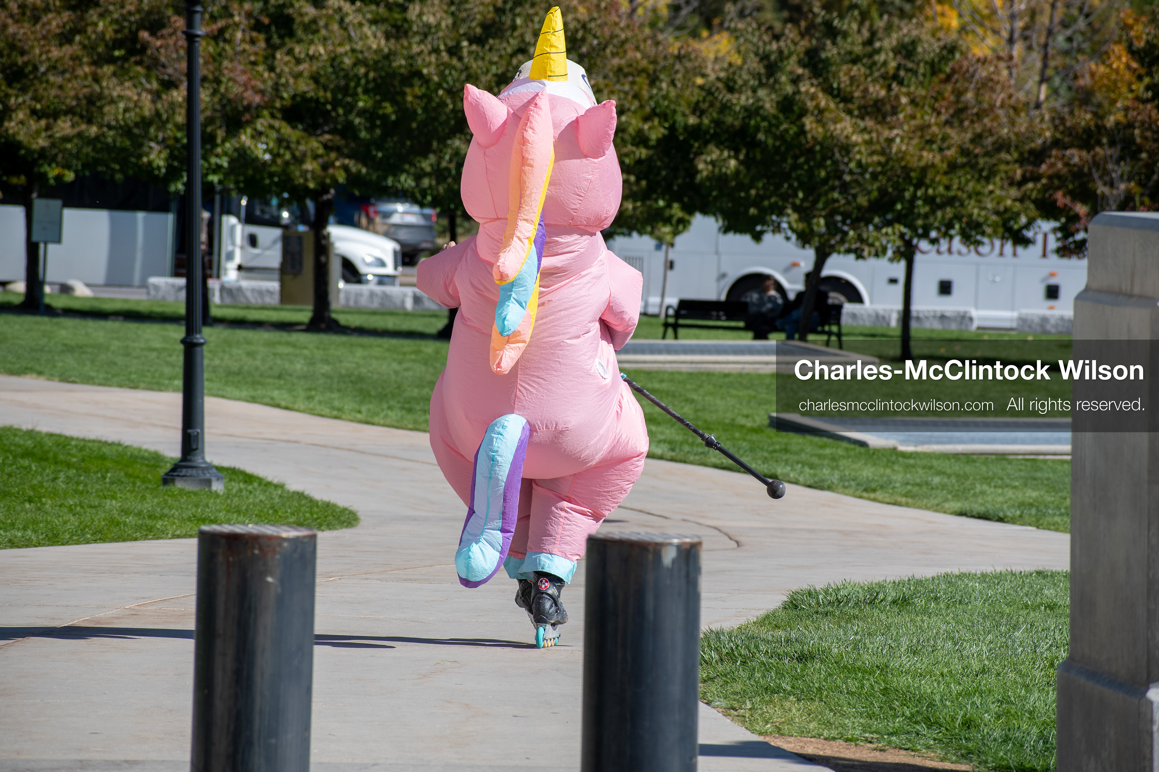 October 18, 2025, Salt Lake City, Utah, USA: A demonstrator in a pink inflatable unicorn costume walks through a park during a "No Kings" protest at the Utah State Capitol in Salt Lake City, Utah. The protest was part of a nationwide mobilization.