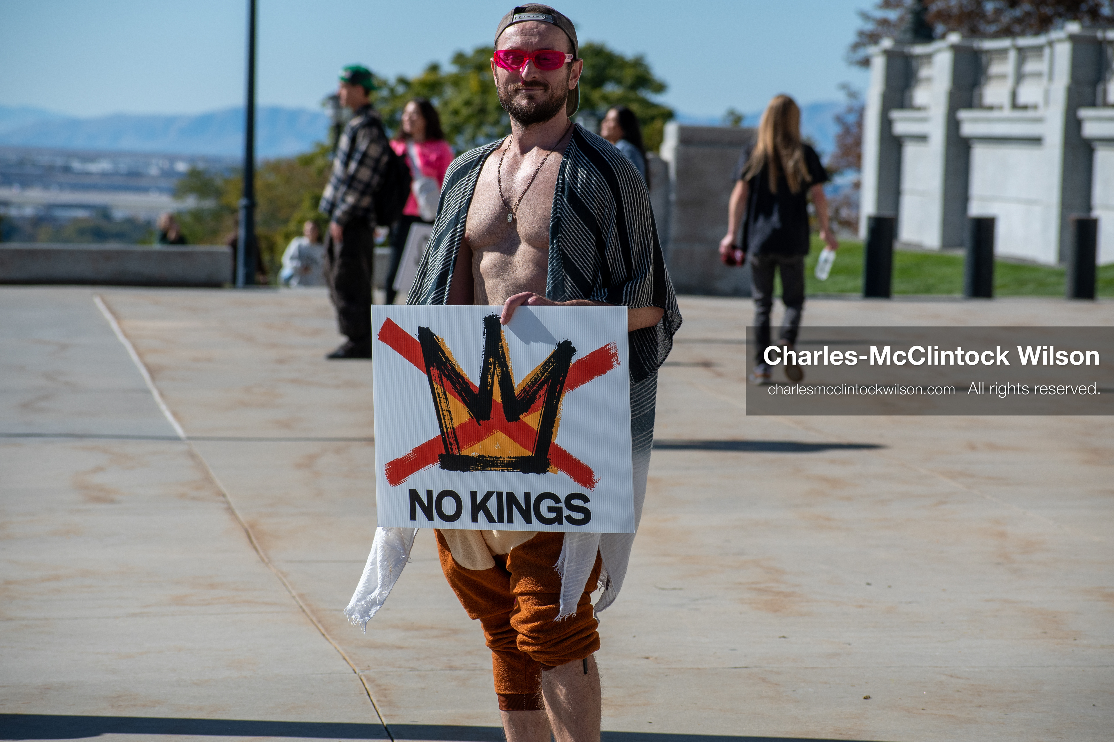 October 18, 2025, Salt Lake City, Utah, USA: A demonstrator holds a sign featuring a crossed-out crown and the phrase "No Kings" during a protest outside a government building in Salt Lake City, Utah. The protest was part of a nationwide mobilization.