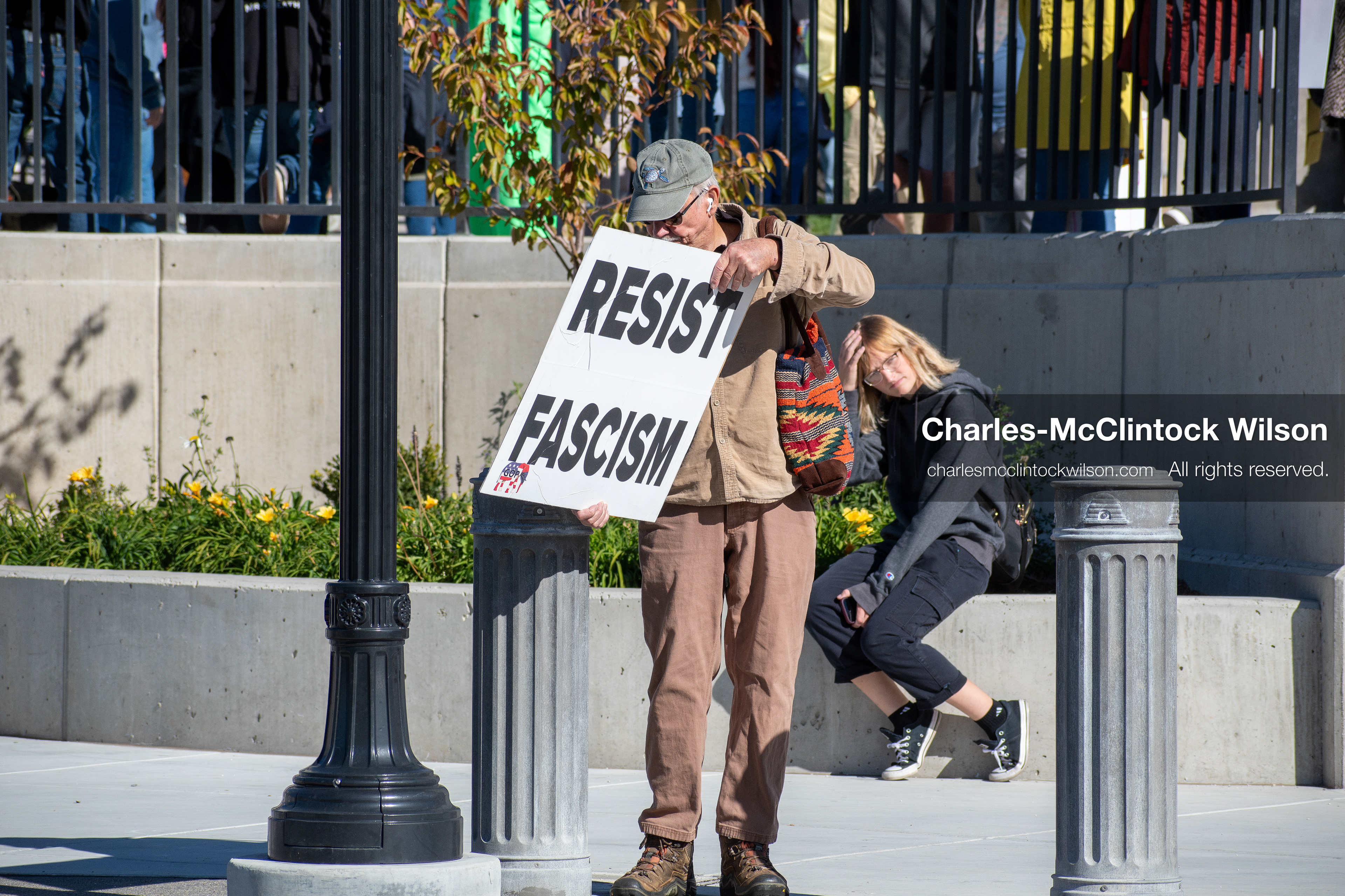 October 18, 2025, Salt Lake City, Utah, USA: A demonstrator raises a placard during a "No Kings" protest held at the Utah State Capitol. Other participants and signs are visible in the background during the public gathering.