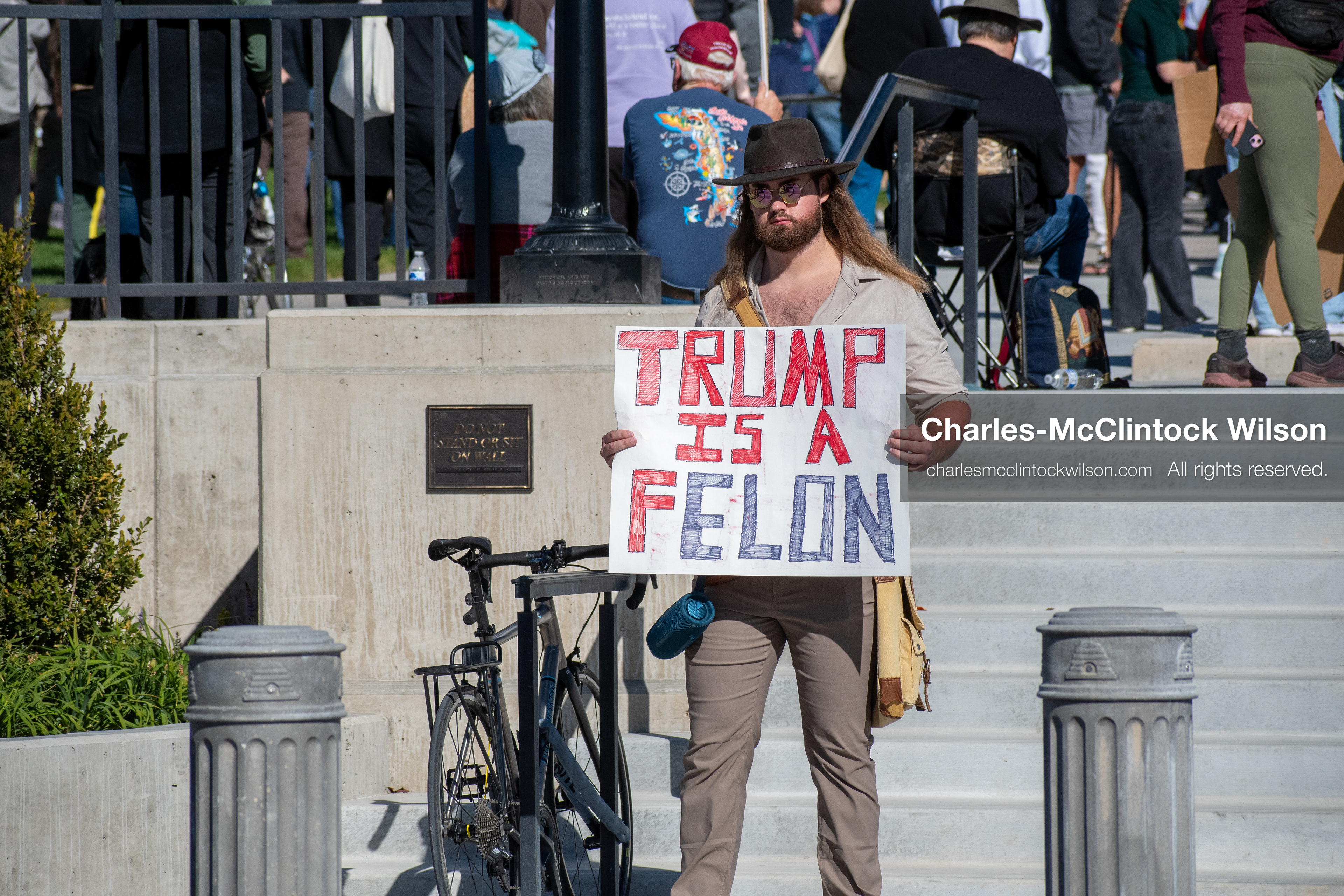 October 18, 2025, Salt Lake City, Utah, USA: A demonstrator raises a placard during a "No Kings" protest held at the Utah State Capitol. Other participants and signs are visible in the background during the public gathering.