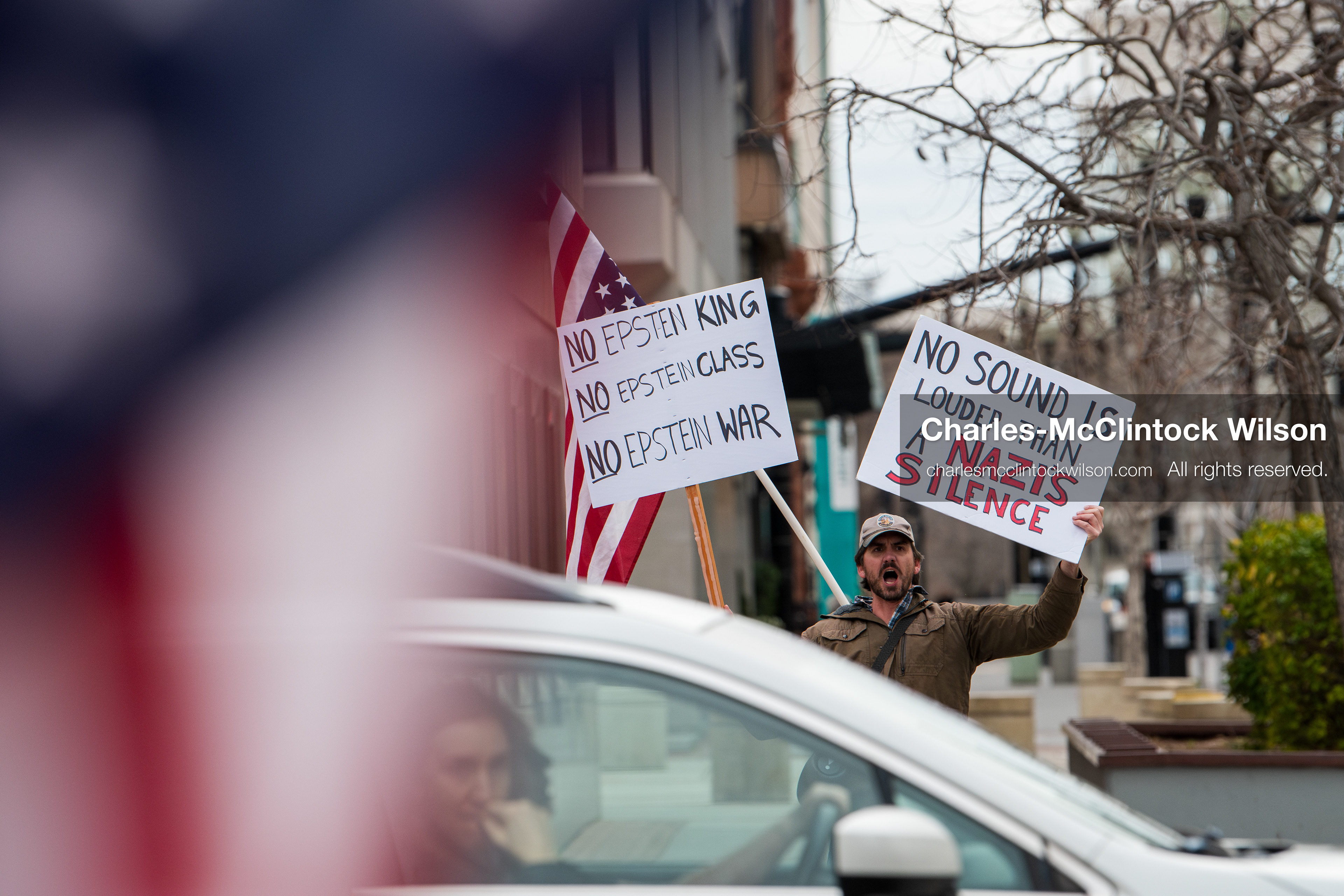 January 3, 2026, Salt Lake City, Utah, USA: A protester holds signs and an American flag during a demonstration against US action in Venezuela outside the Wallace Federal Building in Salt Lake City, Utah. The protest was part of a nationwide mobilization responding to recent military developments. (Credit Image: (c) Charles‑McClintock Wilson/ZUMA Press Wire)