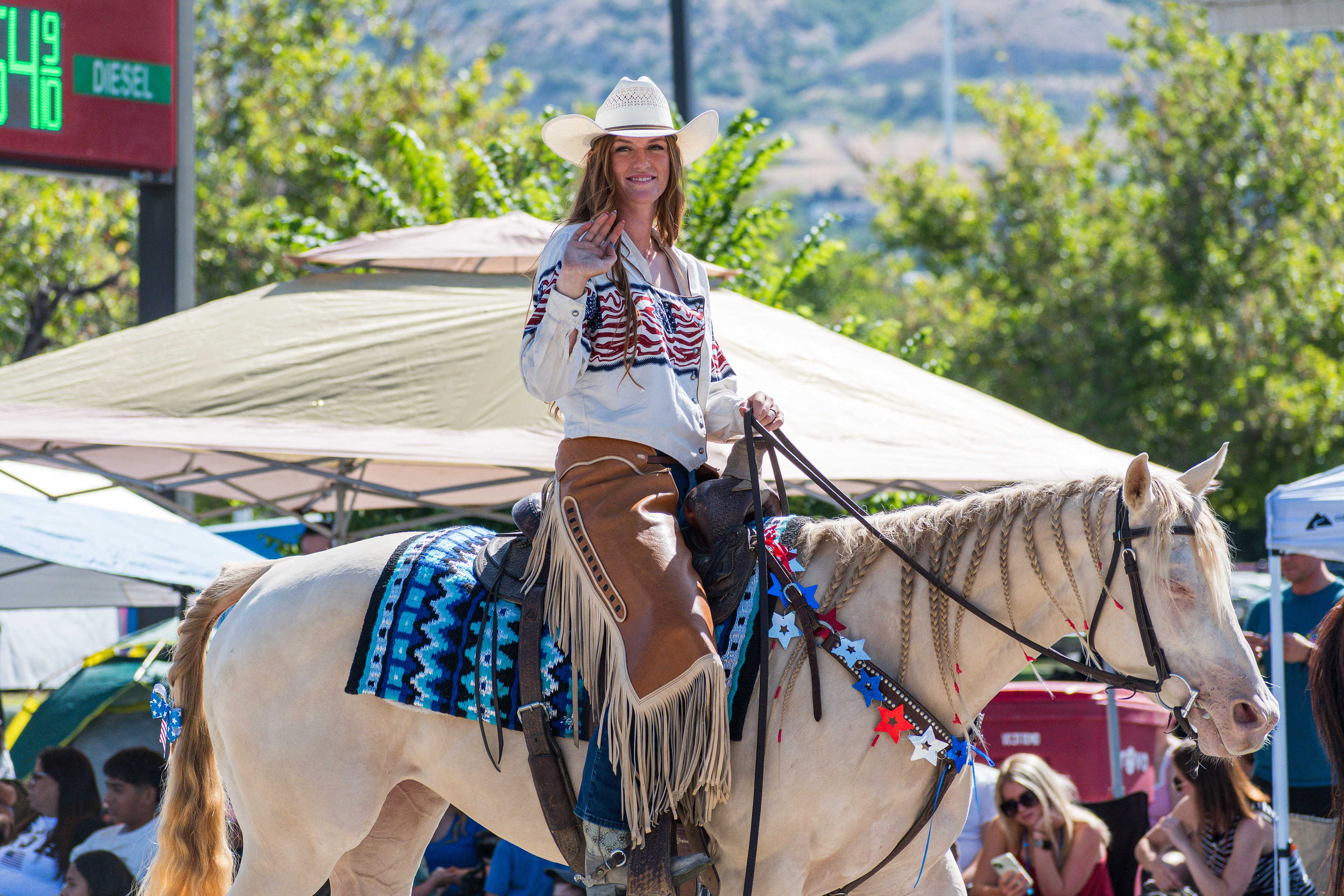 Provo, Utah – July 4, 2025: A woman waves while riding a horse during the Freedom Festival Grand Parade in downtown Provo.