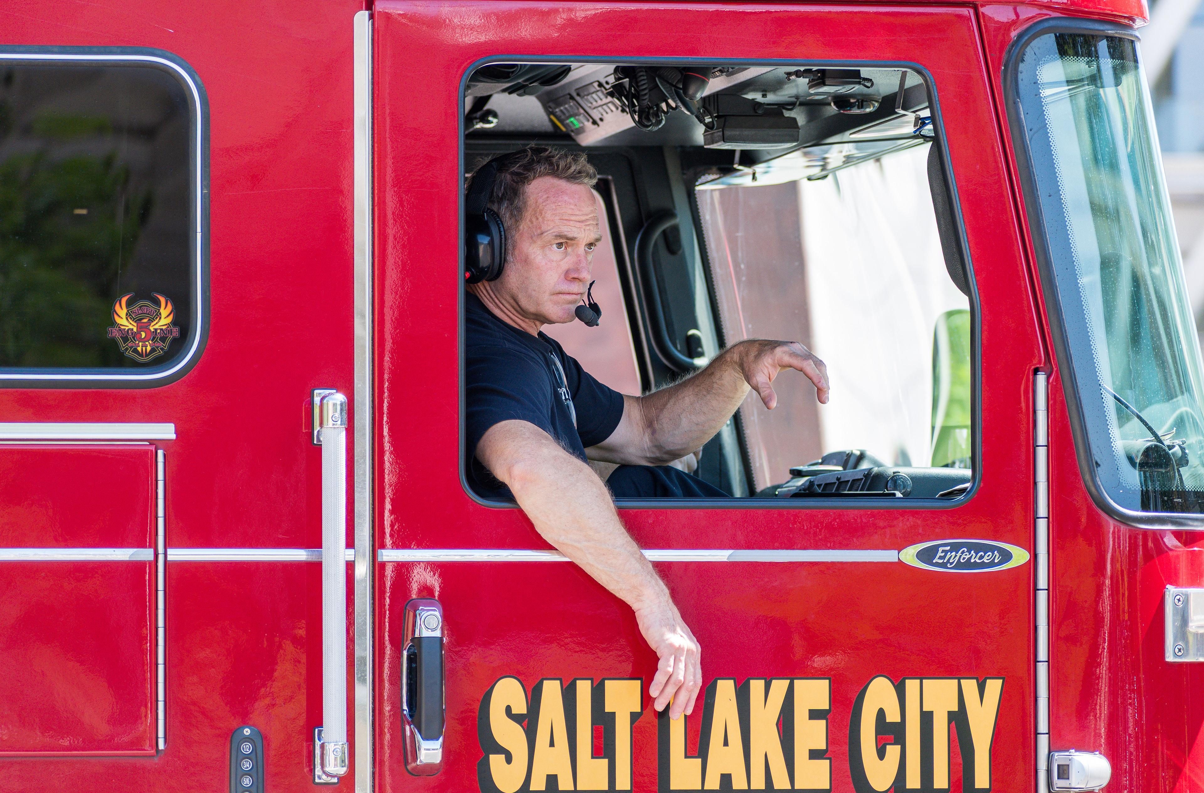 SALT LAKE CITY, UTAH – JUNE 14, 2025: A firefighter with the Salt Lake City Fire Department drives Engine 5 while monitoring the “No Kings” protest at the University of Utah. Fire crews remained on standby to ensure public safety during the demonstration.
