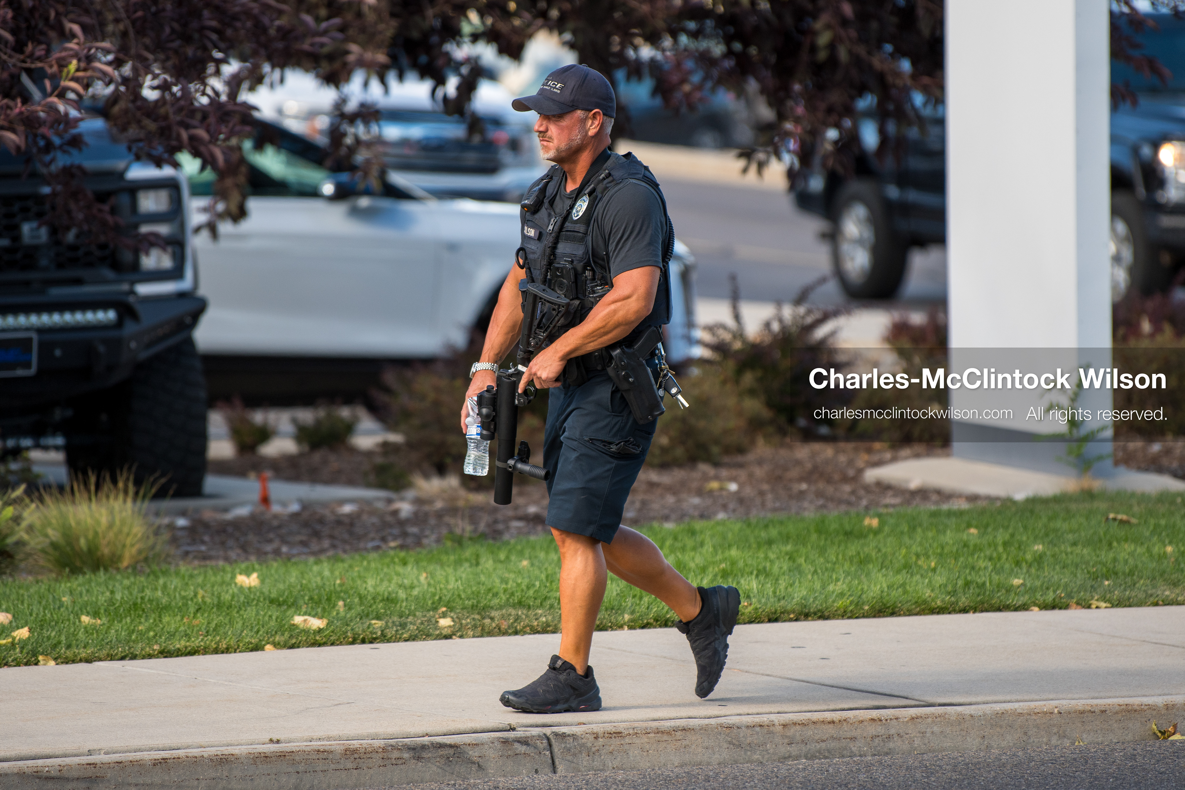 An armed law enforcement officer patrols a sidewalk perimeter outside Intermountain Medical Center in Murray, Utah, United States, on August 17, 2026. Multiple regional police agencies secured the hospital perimeter as a safety precaution after shooting victims were admitted following a fatal shootout outside a funeral service in nearby Kearns. (Photo by Charles-McClintock Wilson/NurPhoto)