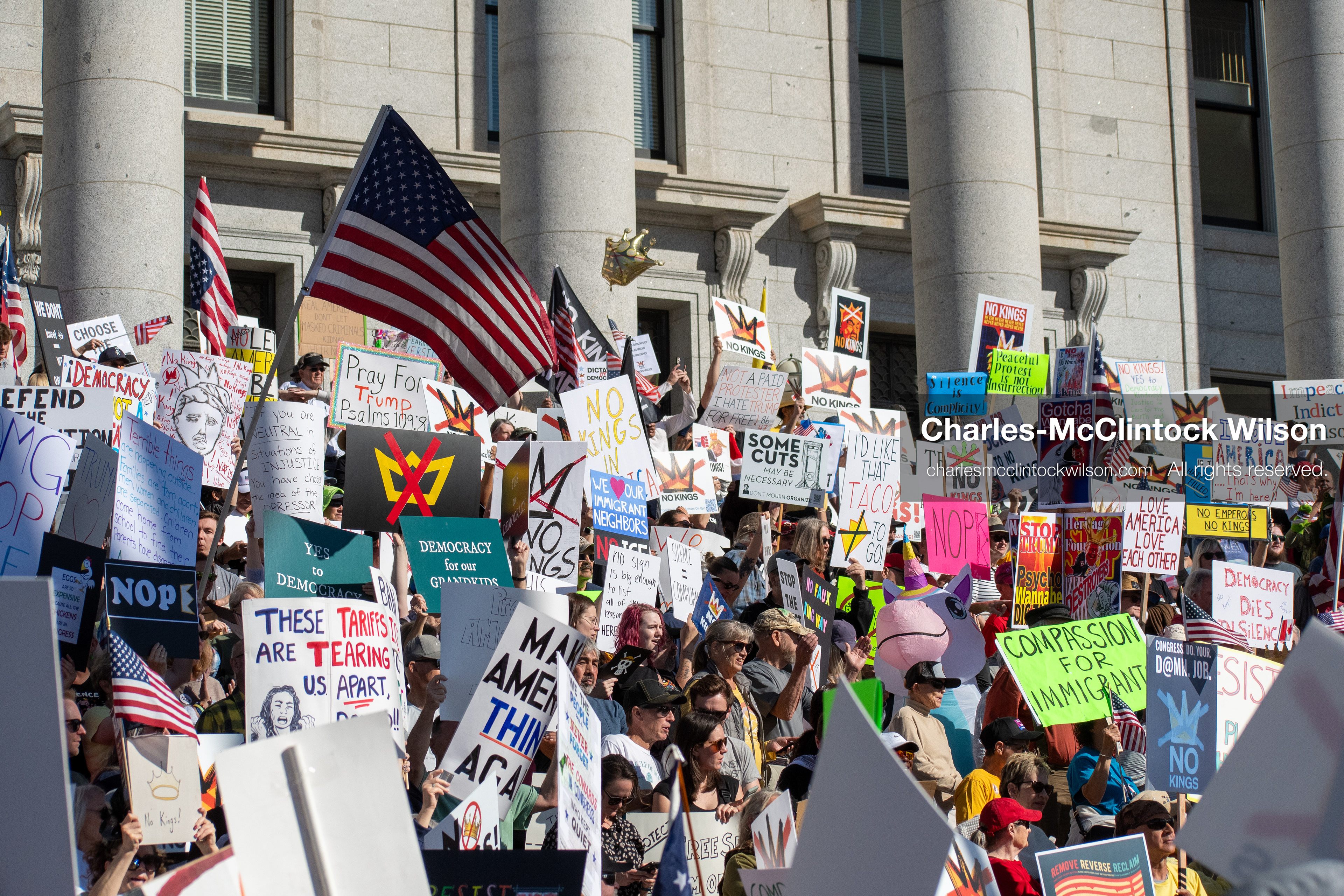 October 18, 2025, Salt Lake City, Utah, USA: Demonstrators gather on the steps of the Utah State Capitol during a "No Kings" protest held as part of a nationwide mobilization. Participants hold signs and flags while documenting the event. The protest was one of several organized across the United States.