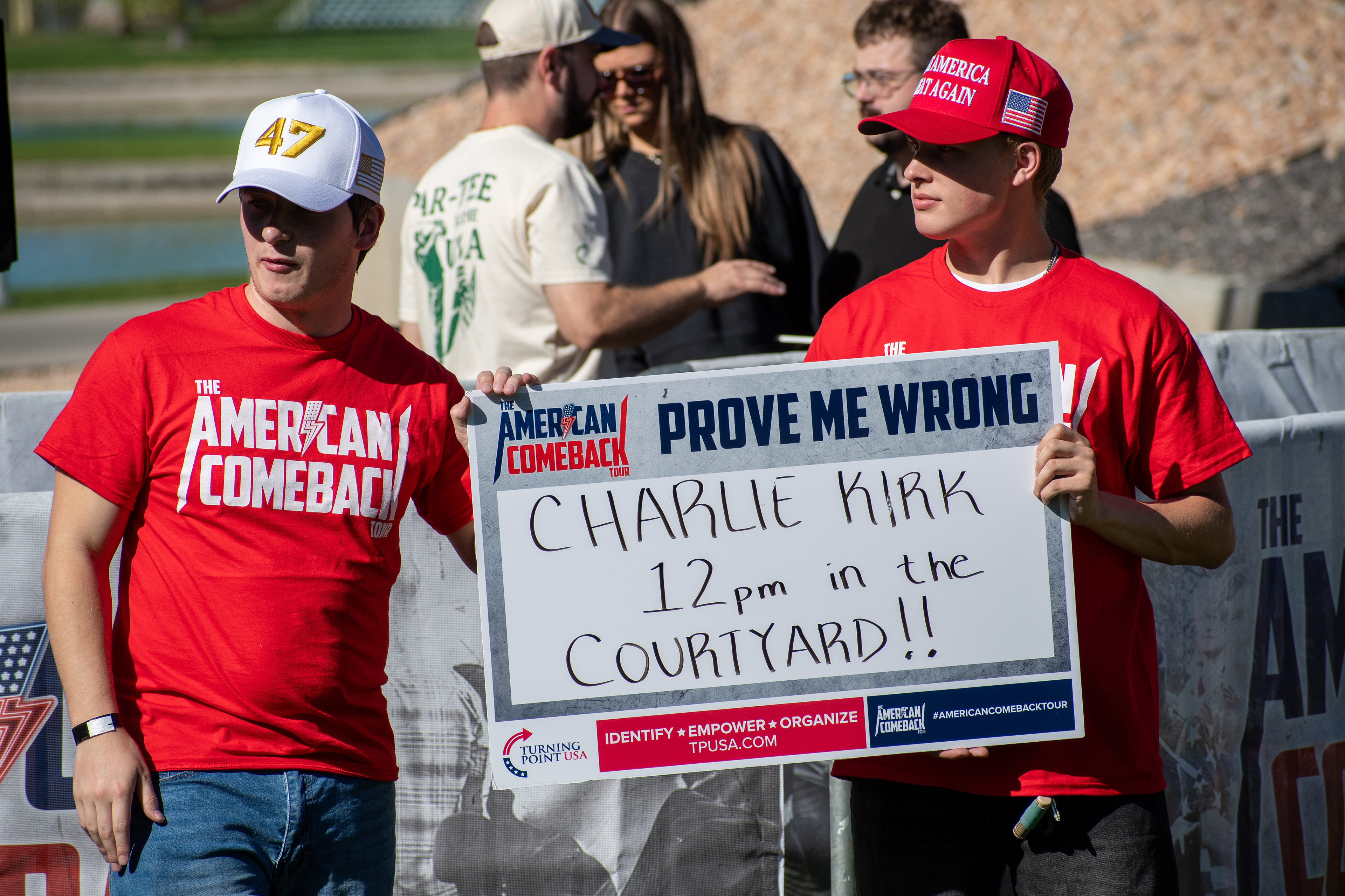 OREM, UTAH – SEPTEMBER 10, 2025: Attendees hold signage and wear matching red shirts at Utah Valley University during the opening stop of the American Comeback Tour. Positioned near the courtyard, the group reflects a moment of coordinated presence and public invitation. The image captures the visual messaging and communal energy that shaped the event’s atmosphere. © Charles-McClintock Wilson / ZUMA Press