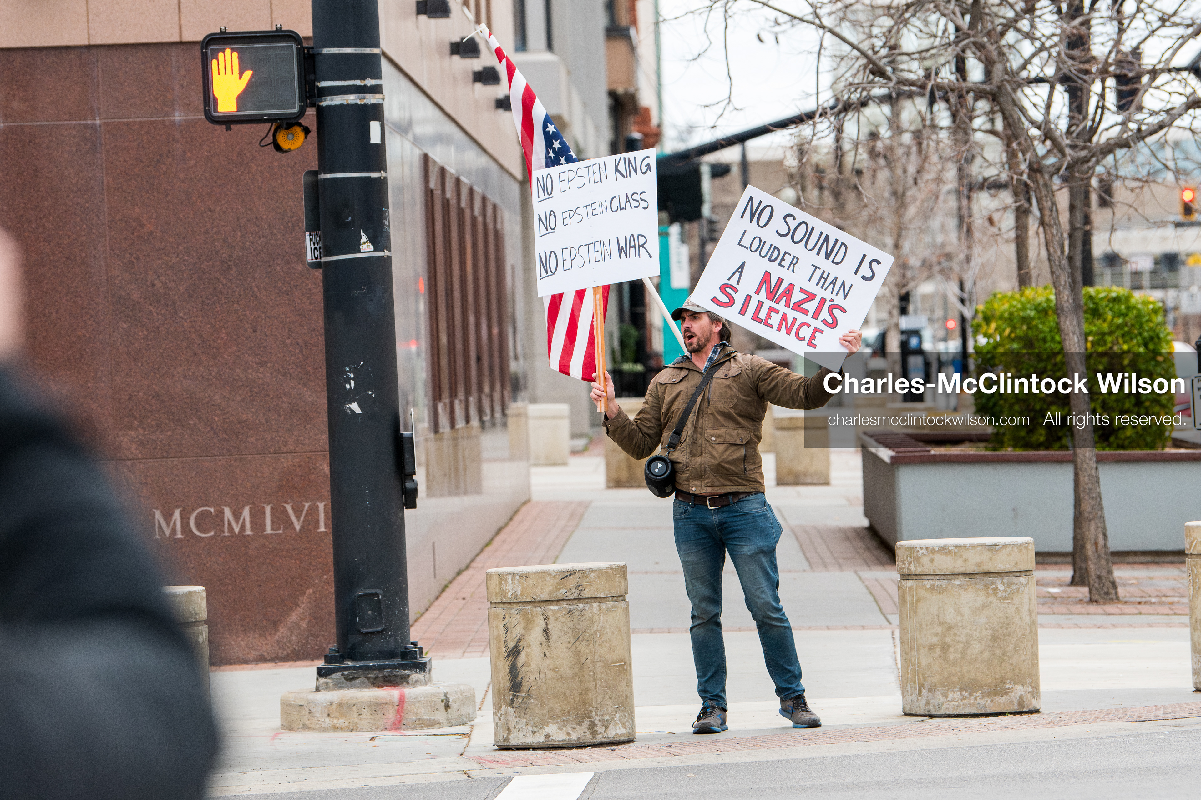 January 3, 2026, Salt Lake City, Utah, USA: A protester holds signs and an American flag during a demonstration against US action in Venezuela outside the Wallace Federal Building in Salt Lake City, Utah. The protest was part of a nationwide mobilization responding to recent military developments. (Credit Image: (c) Charles‑McClintock Wilson/ZUMA Press Wire)