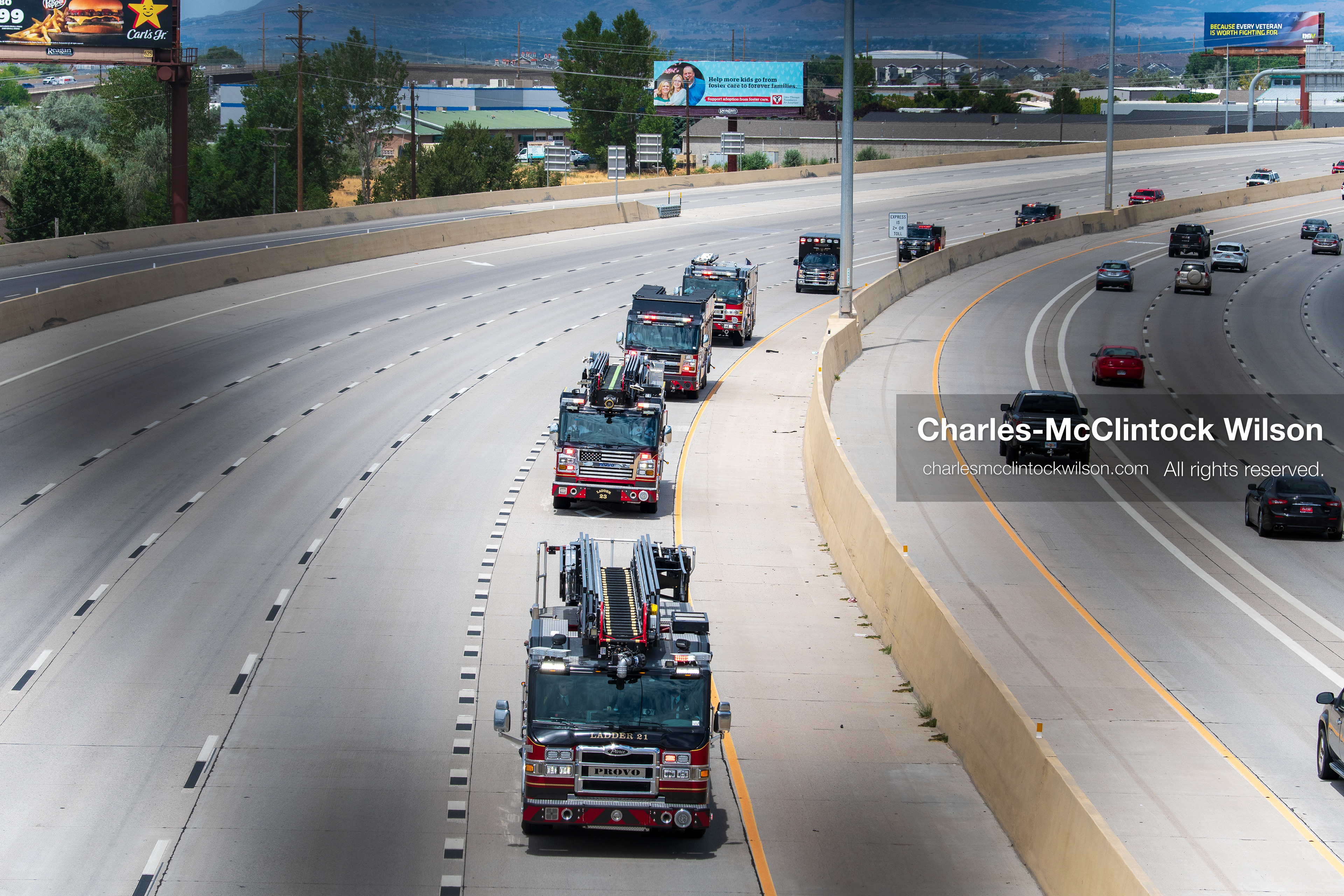 A long line of fire engines and emergency response vehicles travels in a single file column along the express lane of Interstate 15 during a funeral procession for Provo Fire Captain Spencer Long and his family in Orem, Utah, on Wednesday, July 29, 2026. More than 300 people came to the public memorial ceremony to honor the five family members who died after a flash flood hit their campsite near the Sunglow Campground in Wayne County. (Photo by Charles-McClintock Wilson/Sipa USA)