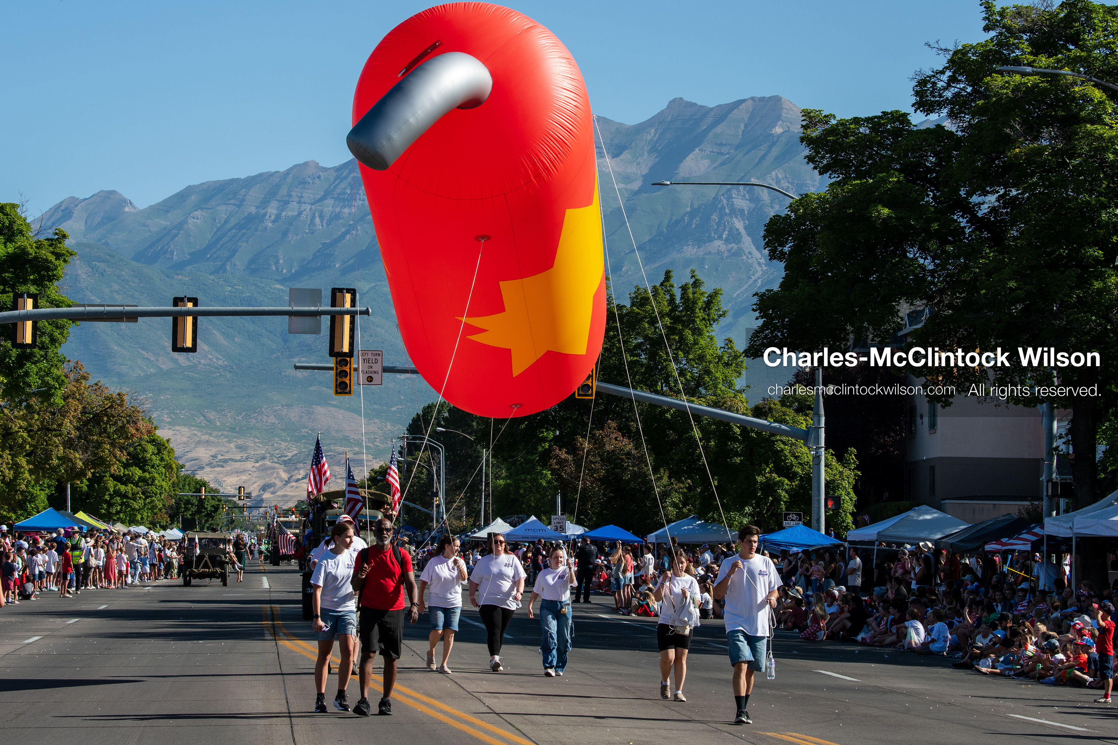 July 4, 2026, Provo, Utah, USA: Handlers guide a large, orange capsule-shaped helium balloon down the street past crowds during America's Freedom Festival Grand Parade in Provo, Utah, Saturday, July 4, 2026. The annual Independence Day event features expanded programming to honor the 250th anniversary of United States independence. (Credit Image: © Charles-McClintock Wilson/ZUMA Press Wire)