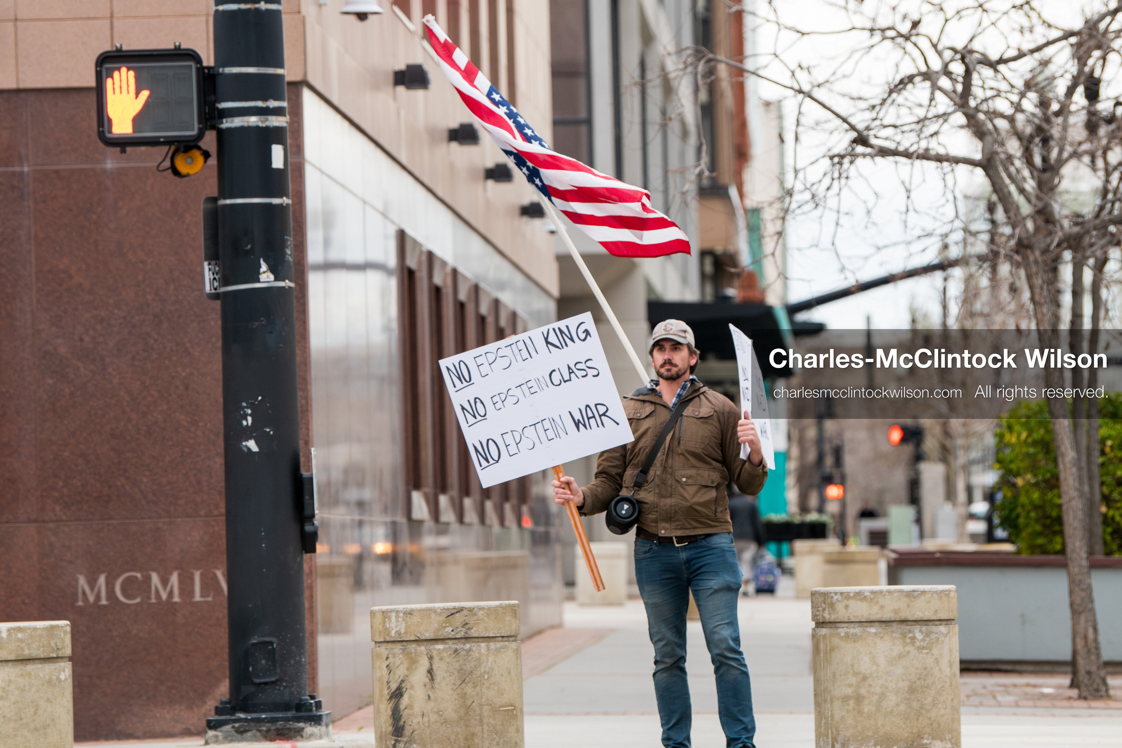 January 3, 2026, Salt Lake City, Utah, USA: A protester holds signs and an American flag during a demonstration against US action in Venezuela outside the Wallace Federal Building in Salt Lake City, Utah. The protest was part of a nationwide mobilization responding to recent military developments. (Credit Image: (c) Charles‑McClintock Wilson/ZUMA Press Wire)