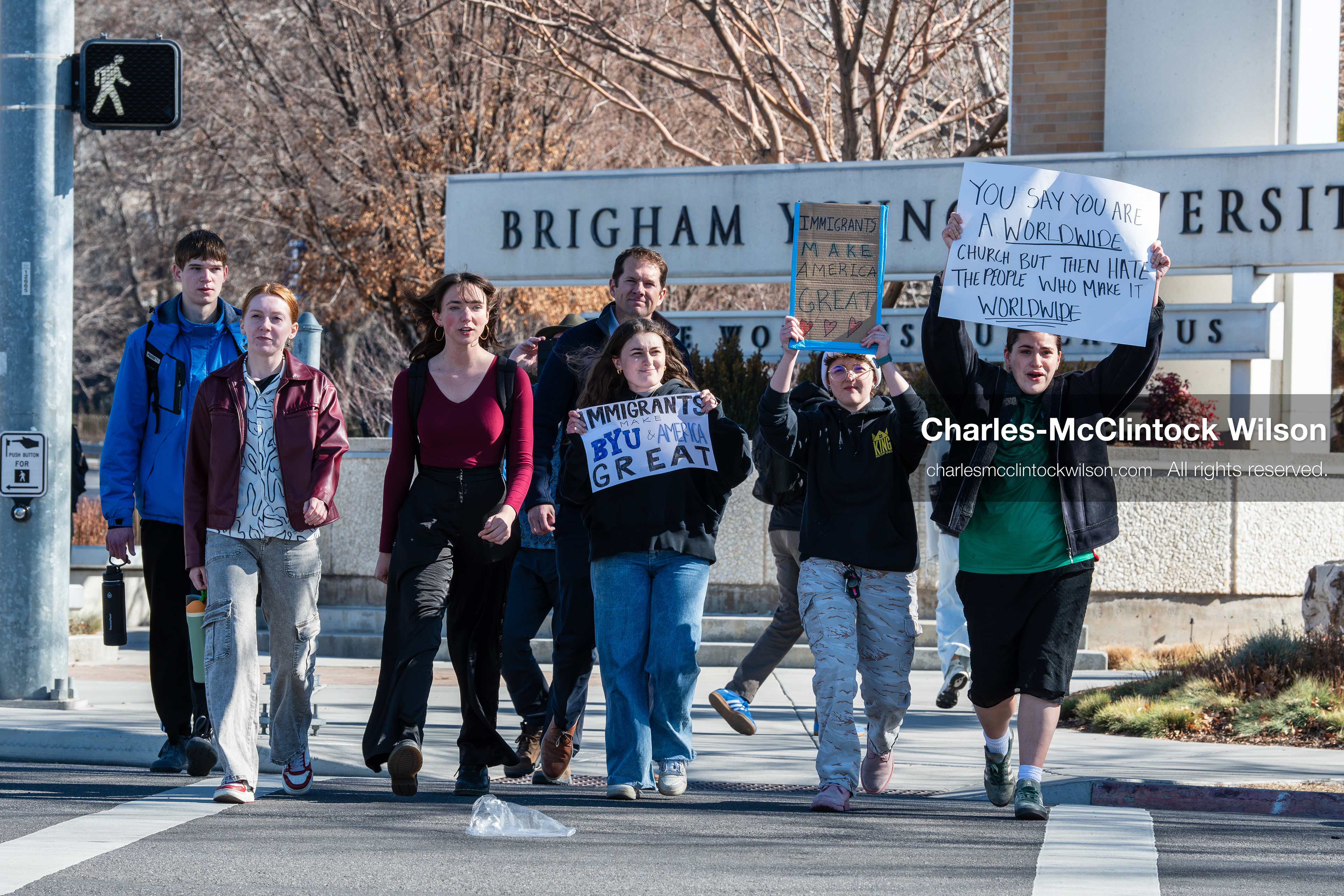 February 5, 2026, Provo, Utah, USA: People walk near the Brigham Young University entrance in Provo as demonstrators carrying signs gather to protest the presence of US Customs and Border Protection recruiters at a career fair held on the BYU campus. (Credit Image: © Charles McClintock Wilson/ZUMA Press Wire)