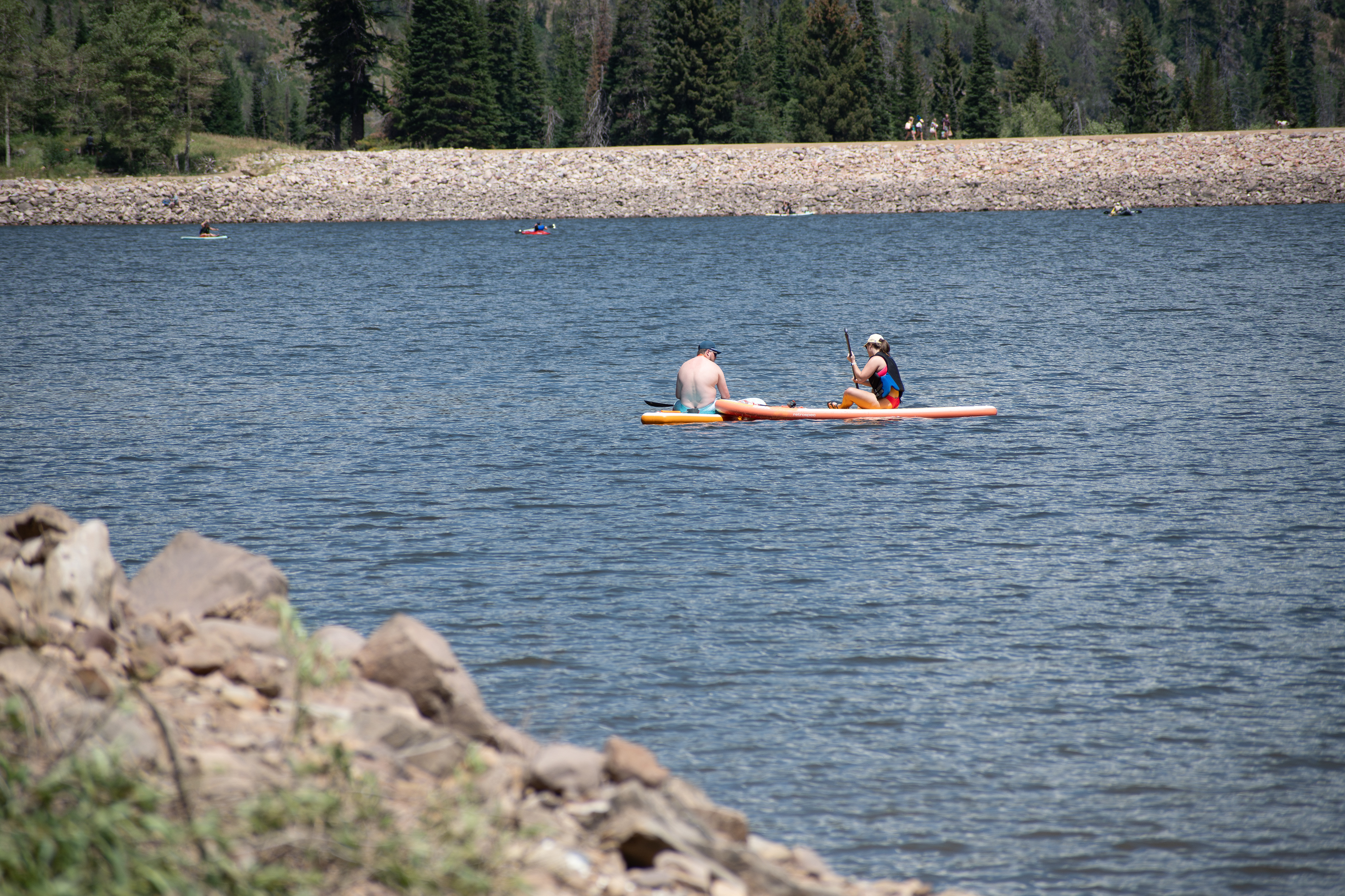 Summit County, Utah – July 20, 2025: People paddleboard across the calm waters of Smith and Morehouse Reservoir during a summer outing.