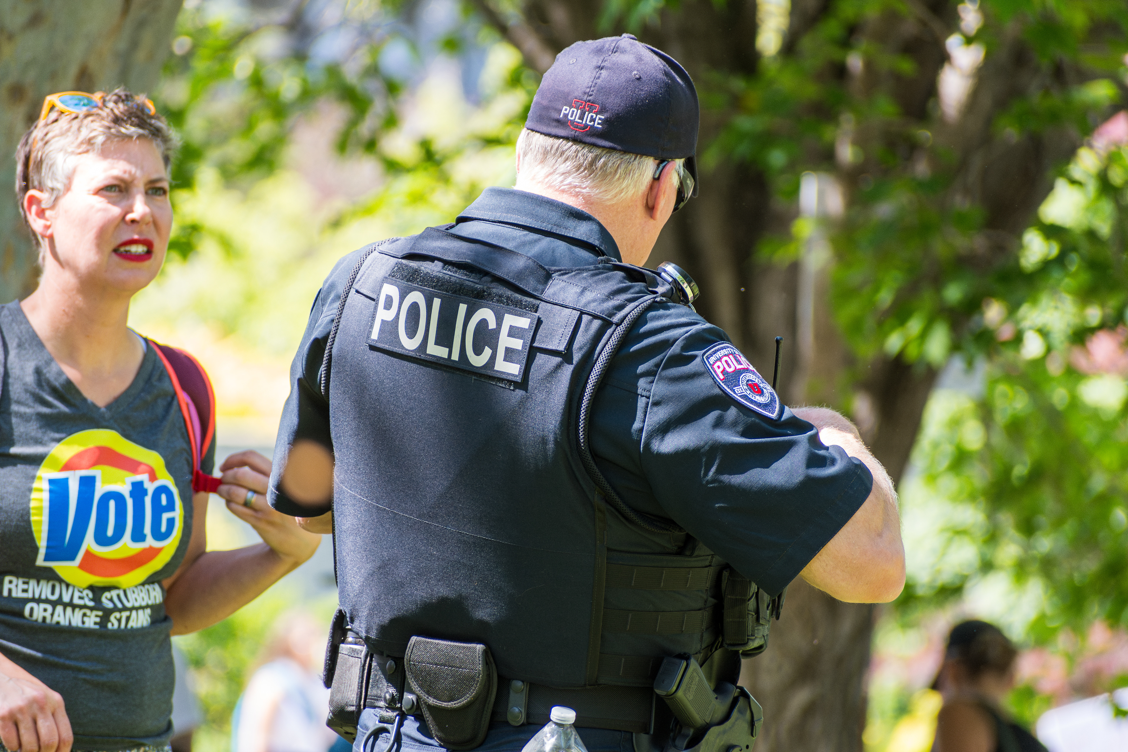 SALT LAKE CITY, UTAH – JUNE 14, 2025: A police officer speaks with an attendee during the “No Kings” protest at the University of Utah. Officers maintained a visible presence throughout the demonstration to ensure public safety.