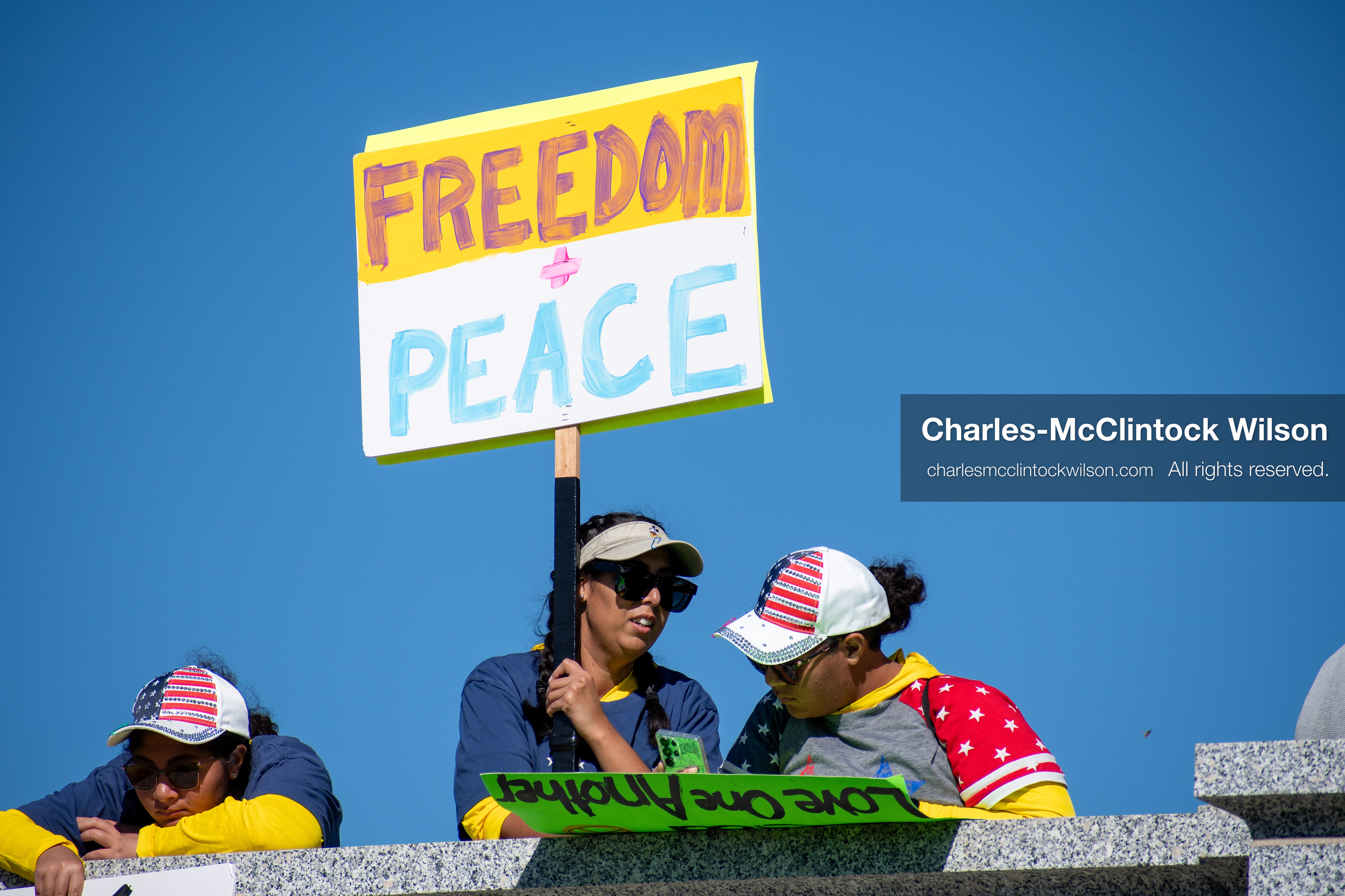 October 18, 2025, Salt Lake City, Utah, USA: A demonstrator raises a placard during a "No Kings" protest held at the Utah State Capitol. Other participants and signs are visible in the background during the public gathering.