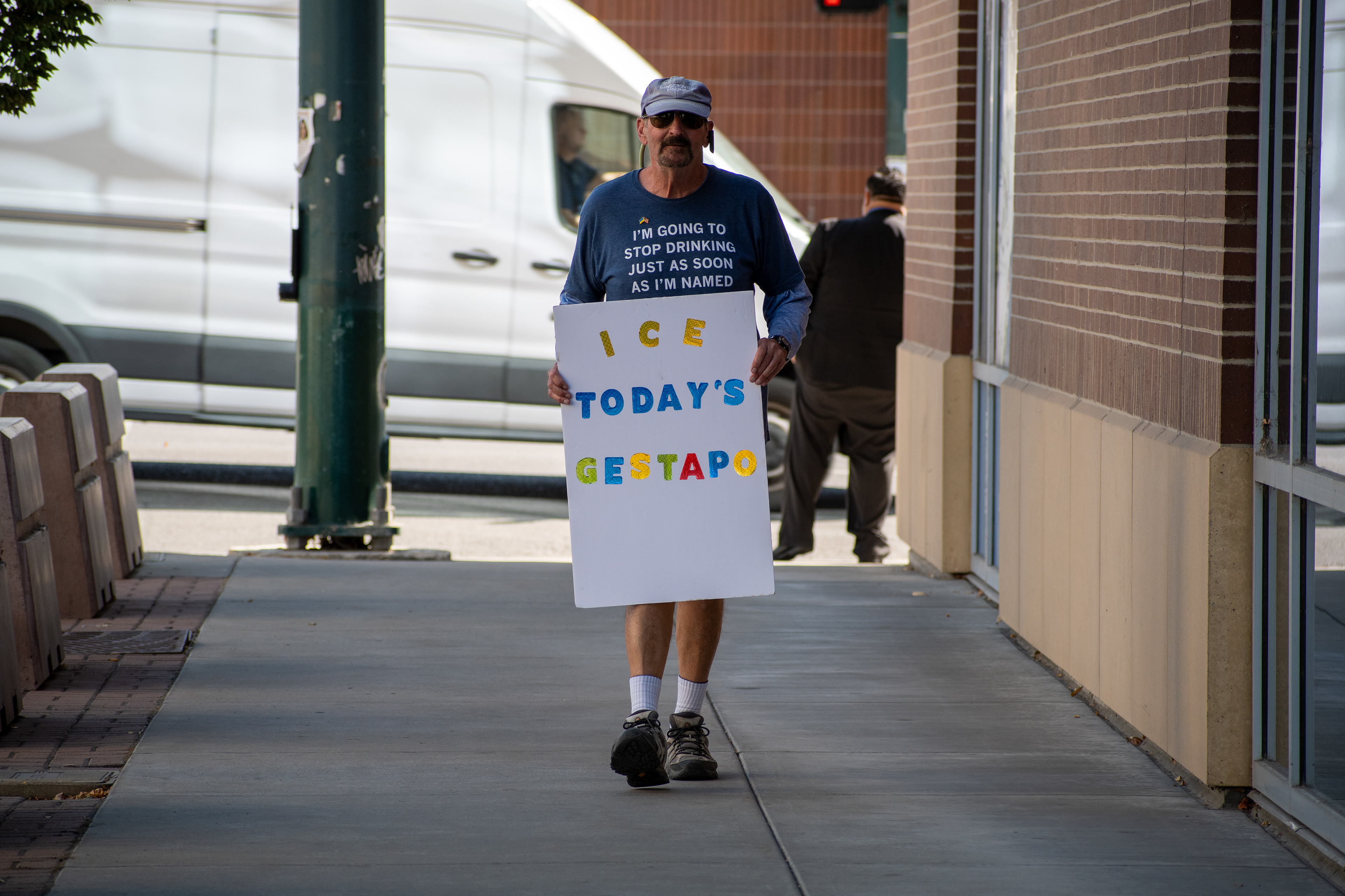 September 15, 2025 – Provo, Utah, United States: A demonstrator stands outside the Utah Valley Convention Center holding a protest sign reading “ICE SUCKER AND LOSER” during the Department of Homeland Security career expo. The individual’s shirt adds satirical commentary on political division and federal leadership. Photograph by Charles‑McClintock Wilson / ZUMA Press Wire