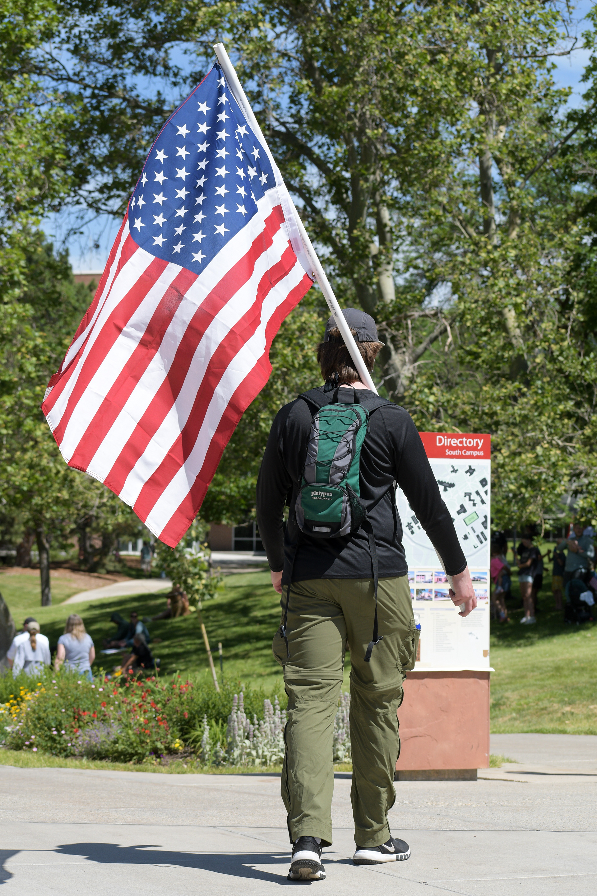 Salt Lake City, Utah – June 14, 2025: A demonstrator walks with an American flag during the “No Kings” protest held at the University of Utah campus.