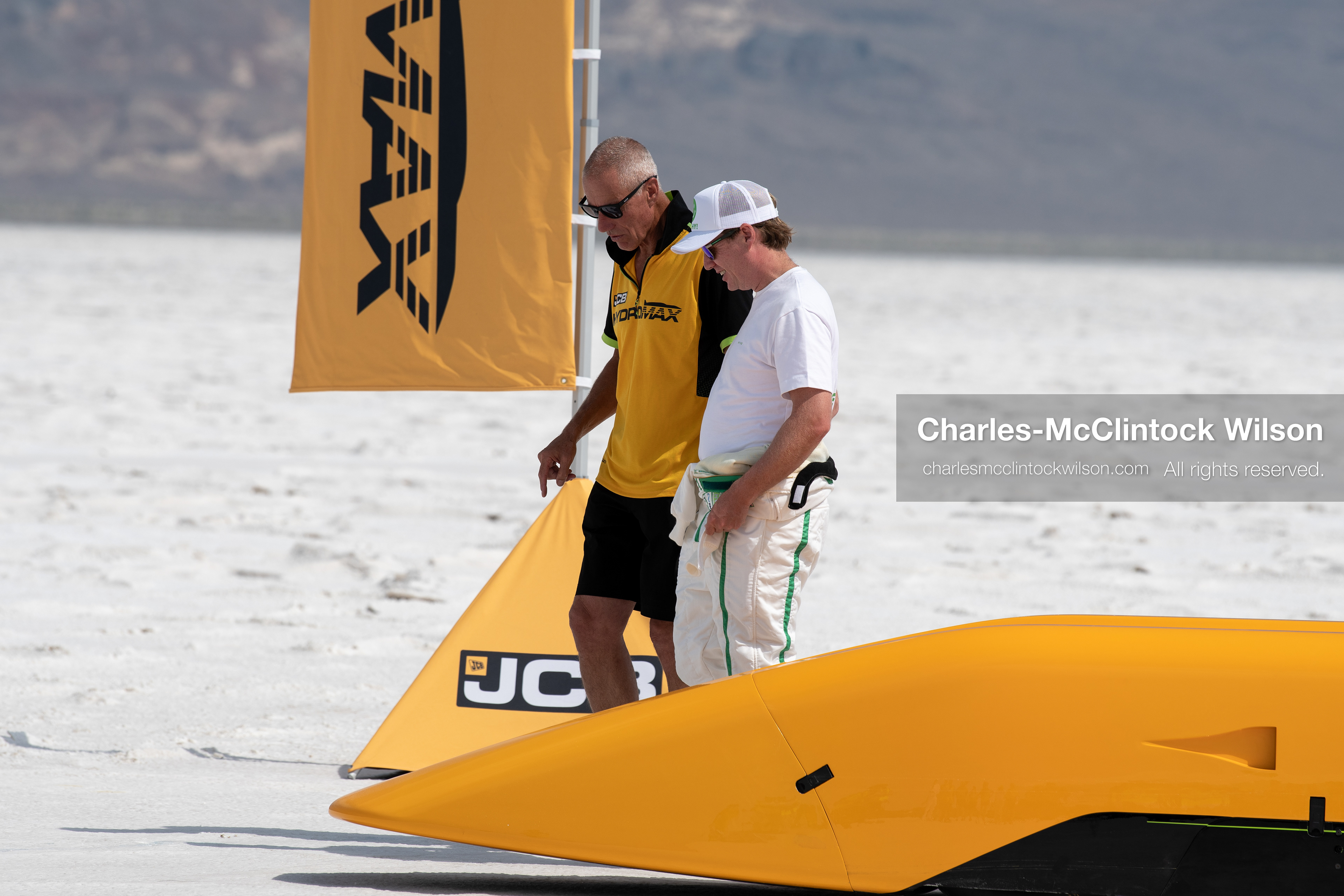 British driver Andy Green walks with a JCB team member beside the hydrogen-powered JCB Hydromax streamliner on the Bonneville Salt Flats near Wendover, Utah, on August 11, 2026, during preparations for a land-speed record run. (Photo by Charles-McClintock Wilson/NurPhoto)