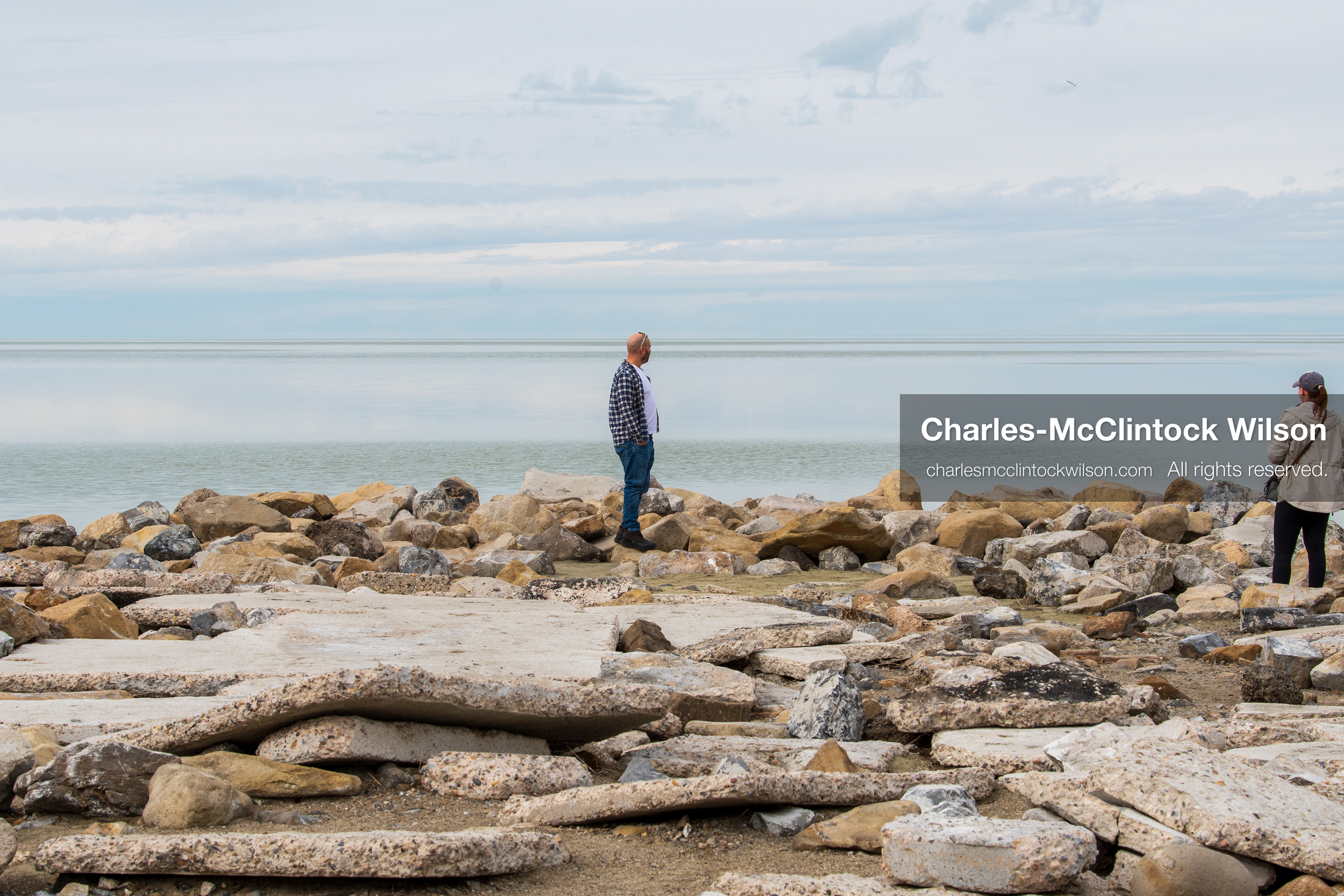 March 1, 2026, Great Salt Lake, Utah, USA: Two people stand along a rocky shoreline at the Great Salt Lake as water levels in the region remain historically low. Reports from state officials and the Great Salt Lake Strike Team state that the lake continues to fall within a serious adverse‑effects range, with elevations among the lowest recorded in more than one hundred years. The lake has drawn increased public attention as lawmakers consider large‑scale water projects and long‑term plans to address declining conditions. (Credit Image: © Charles‑McClintock Wilson/ZUMA Press Wire)