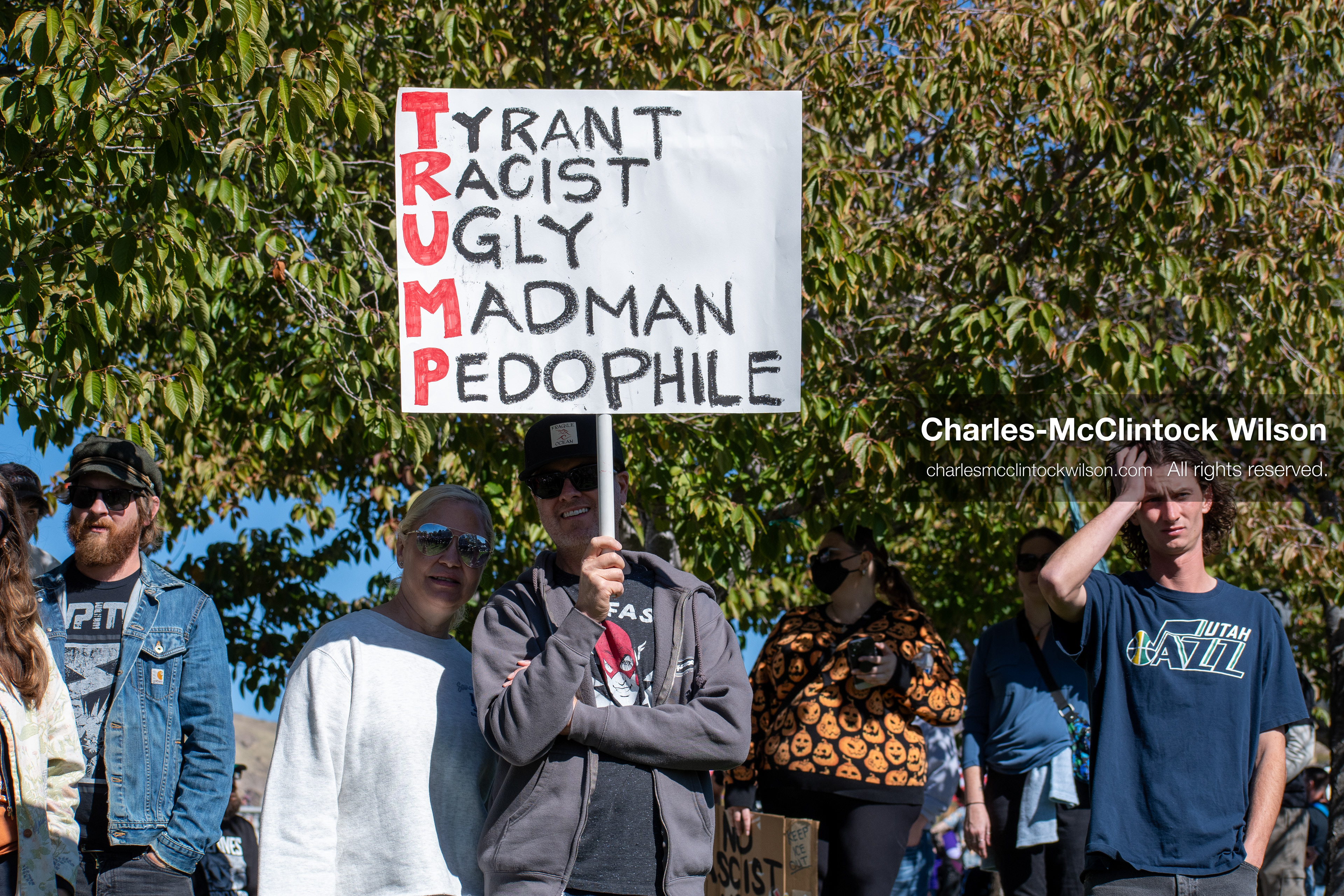 October 18, 2025, Salt Lake City, Utah, USA: A demonstrator raises a placard during a "No Kings" protest held at the Utah State Capitol. Other participants and signs are visible in the background during the public gathering.