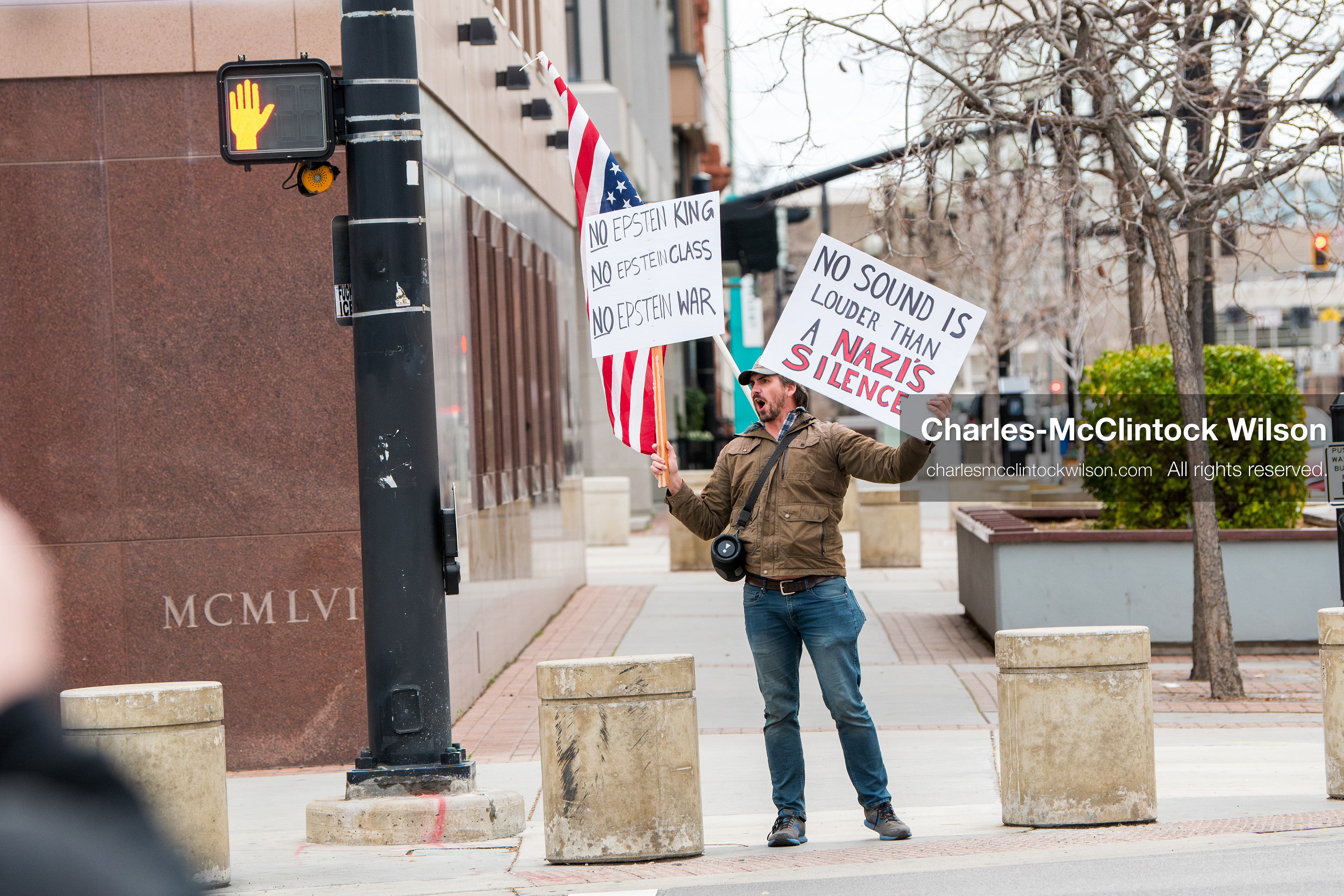 January 3, 2026, Salt Lake City, Utah, USA: A protester holds signs and an American flag during a demonstration against US action in Venezuela outside the Wallace Federal Building in Salt Lake City, Utah. The protest was part of a nationwide mobilization responding to recent military developments. (Credit Image: (c) Charles‑McClintock Wilson/ZUMA Press Wire)