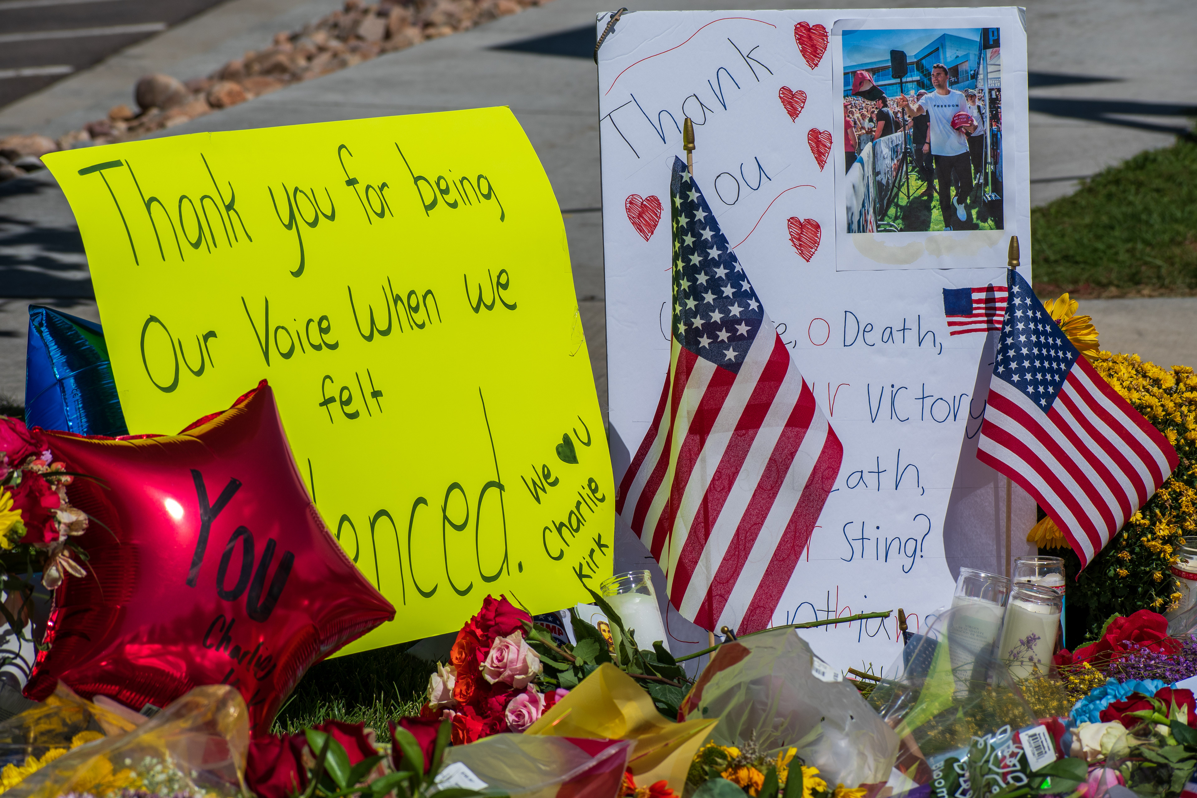 OREM, UTAH – SEPTEMBER 12, 2025: American flags, flowers, balloons, and handwritten posters are arranged at a memorial site for Charlie Kirk near Utah Valley University. The tribute includes photographs and personal messages placed on the grass beside the sidewalk. © Charles‑McClintock Wilson / ZUMA Press