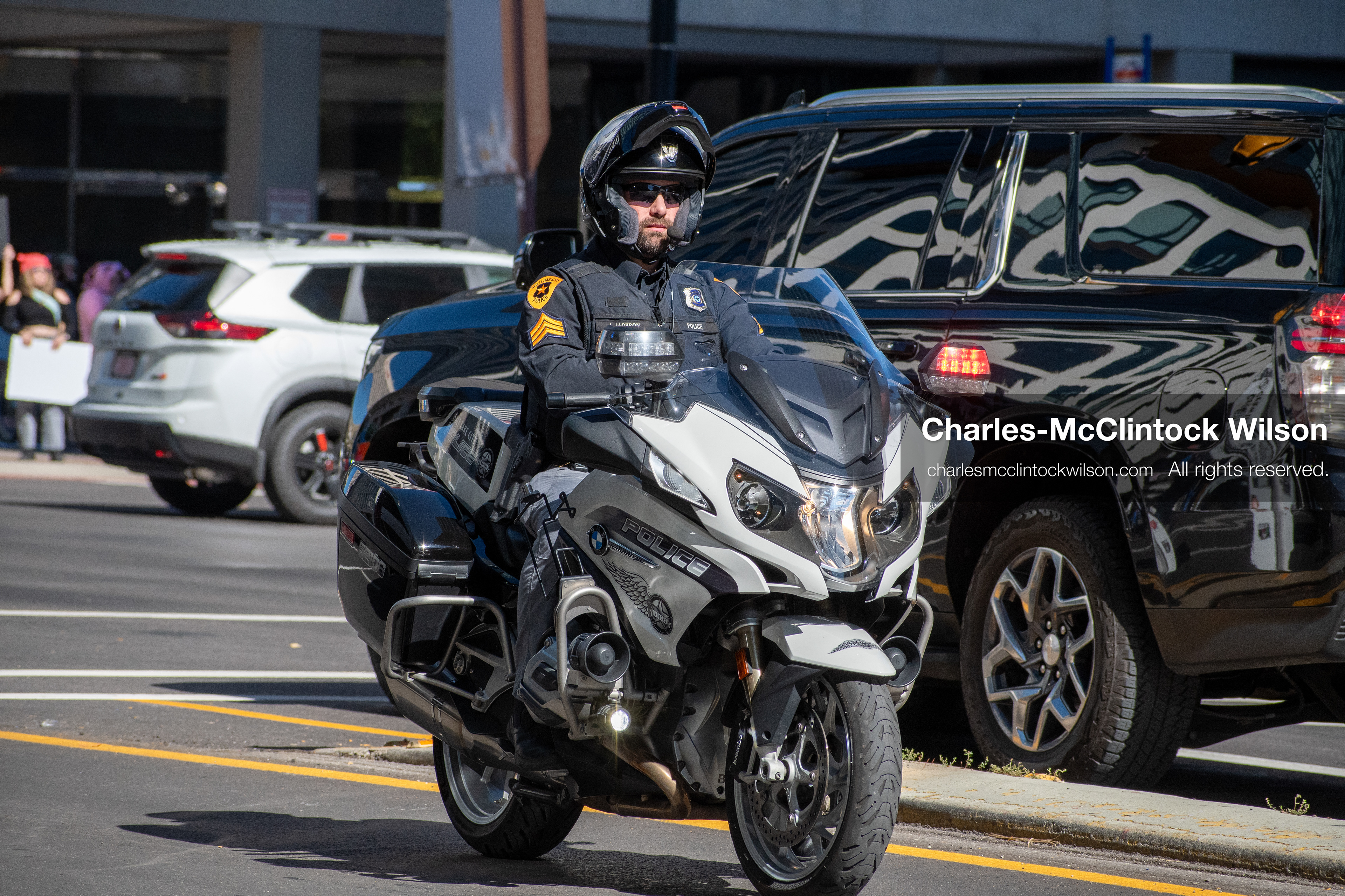 Salt Lake City, Utah — October 18, 2025: A Salt Lake City police officer rides a BMW motorcycle near the Utah State Capitol during a “No Kings” protest. The demonstration, part of a nationwide movement opposing President Donald Trump’s administration, drew thousands in a coordinated call for restraint in executive power and rejection of personality-driven governance.