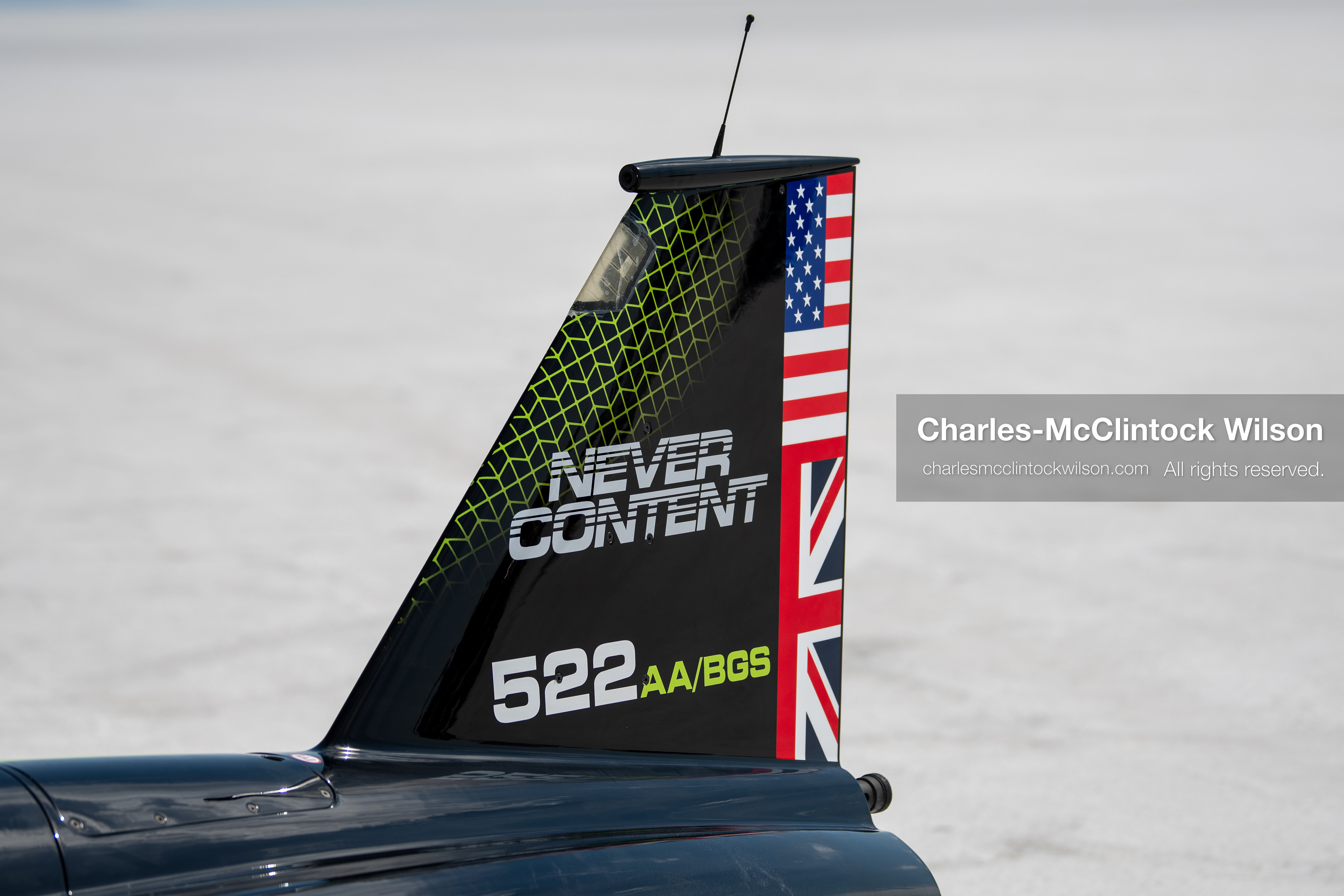 The tail fin of the hydrogen-powered JCB Hydromax streamliner displays the slogan ''Never Content'' and British and American flags on the Bonneville Salt Flats near Wendover, Utah, on August 11, 2026, during preparations for a land-speed record run. (Photo by Charles-McClintock Wilson/NurPhoto)