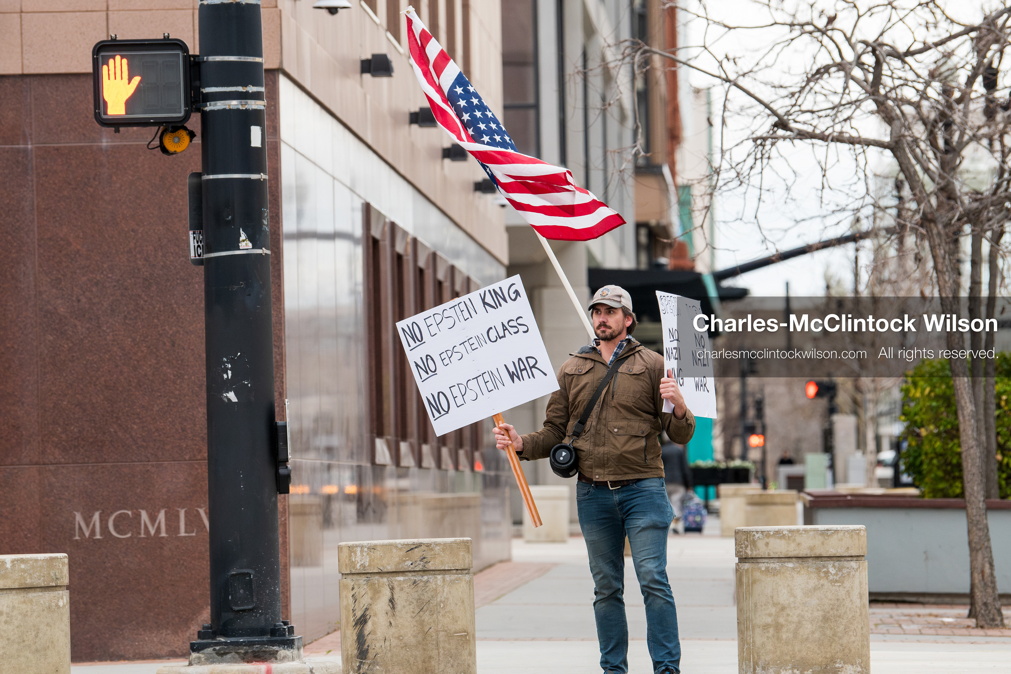 January 3, 2026, Salt Lake City, Utah, USA: A protester holds signs and an American flag during a demonstration against US action in Venezuela outside the Wallace Federal Building in Salt Lake City, Utah. The protest was part of a nationwide mobilization responding to recent military developments. (Credit Image: (c) Charles‑McClintock Wilson/ZUMA Press Wire)