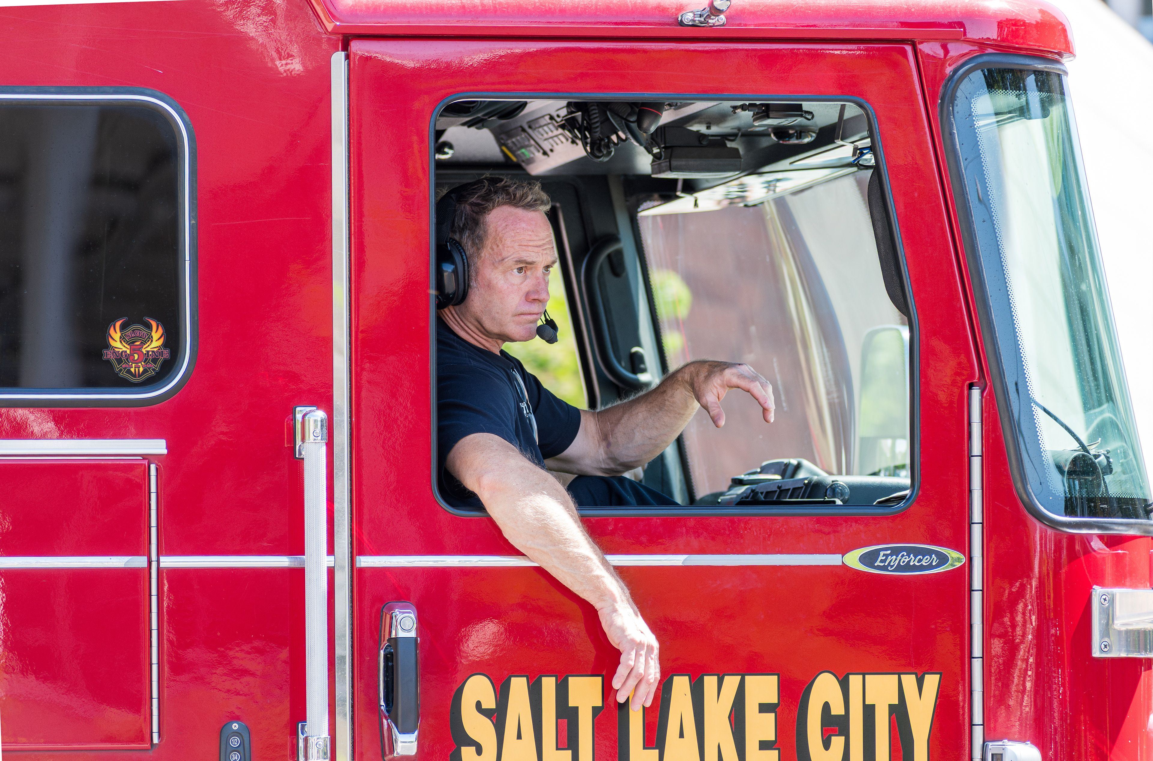 SALT LAKE CITY, UTAH – JUNE 14, 2025: A firefighter with the Salt Lake City Fire Department drives Engine 5 while monitoring the “No Kings” protest at the University of Utah. Fire crews remained on standby to ensure public safety during the demonstration.