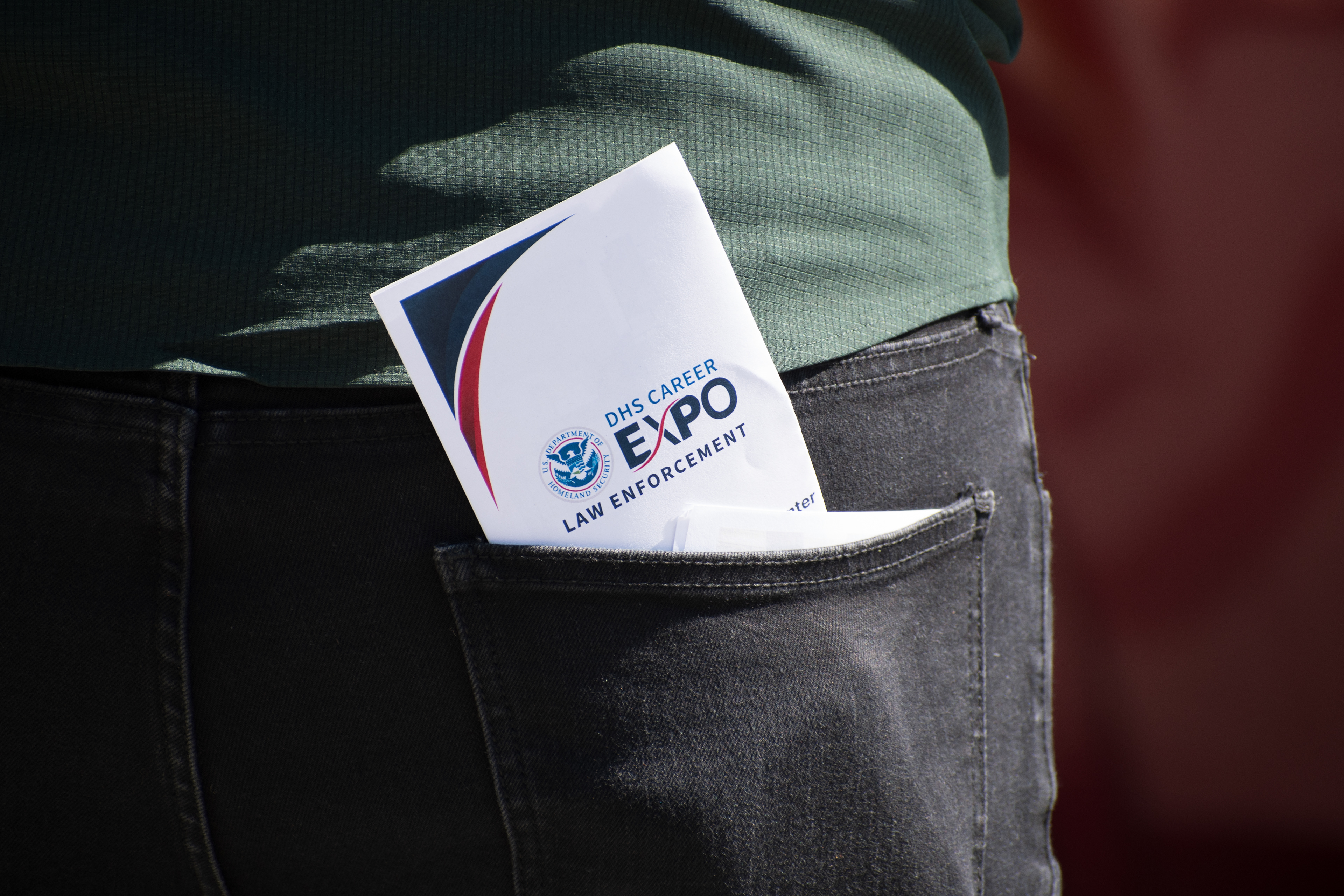 September 15, 2025 – Provo, Utah, United States: A folded pamphlet reading “DHS CAREER EXPO LAW ENFORCEMENT” is tucked into the back pocket of an attendee outside the Utah Valley Convention Center. The event, hosted by the Department of Homeland Security, drew both job seekers and demonstrators voicing opposition to federal enforcement practices. Photograph by Charles‑McClintock Wilson / ZUMA Press Wire