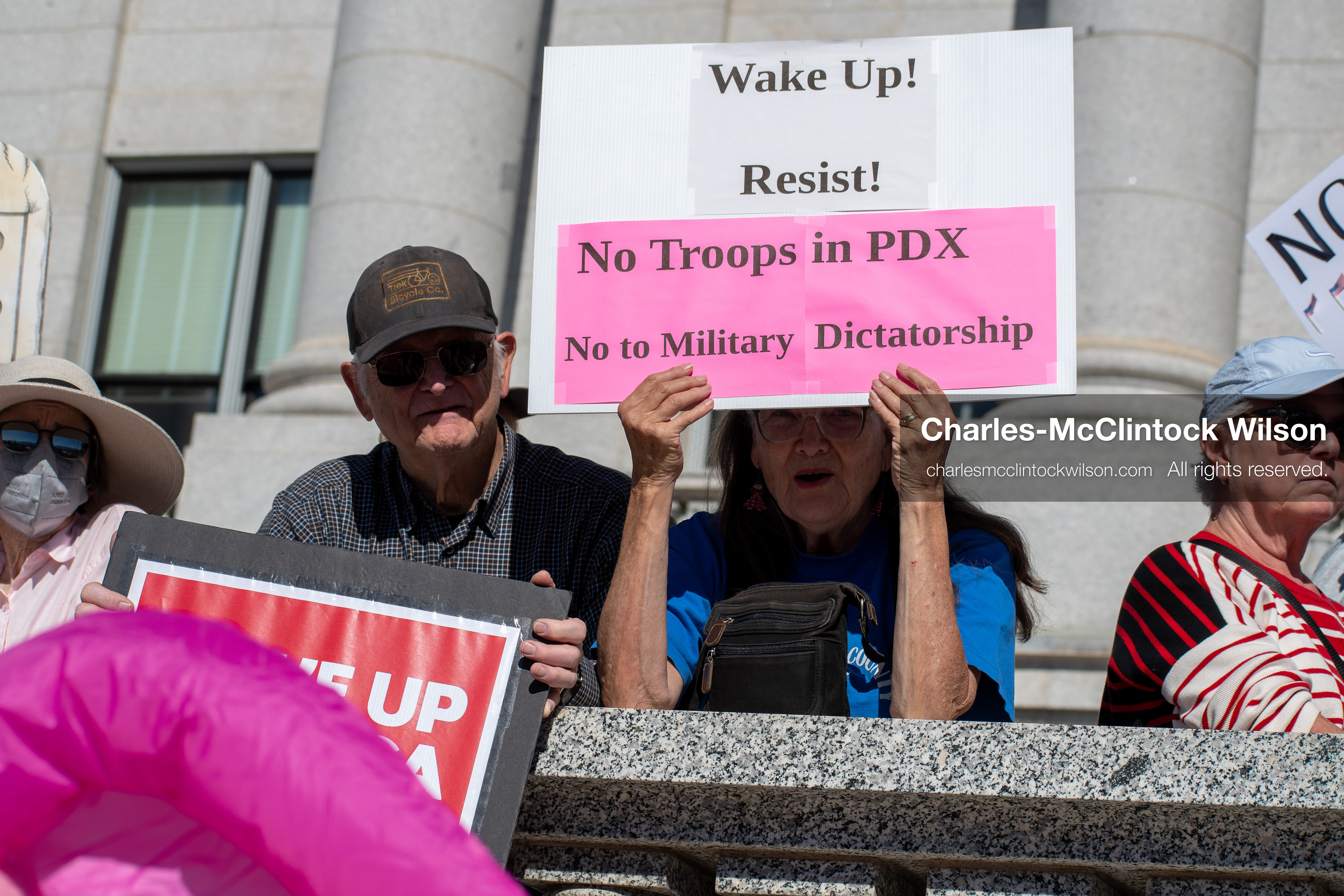 October 18, 2025, Salt Lake City, Utah, USA: A demonstrator raises a placard during a "No Kings" protest held at the Utah State Capitol. Other participants and signs are visible in the background during the public gathering.