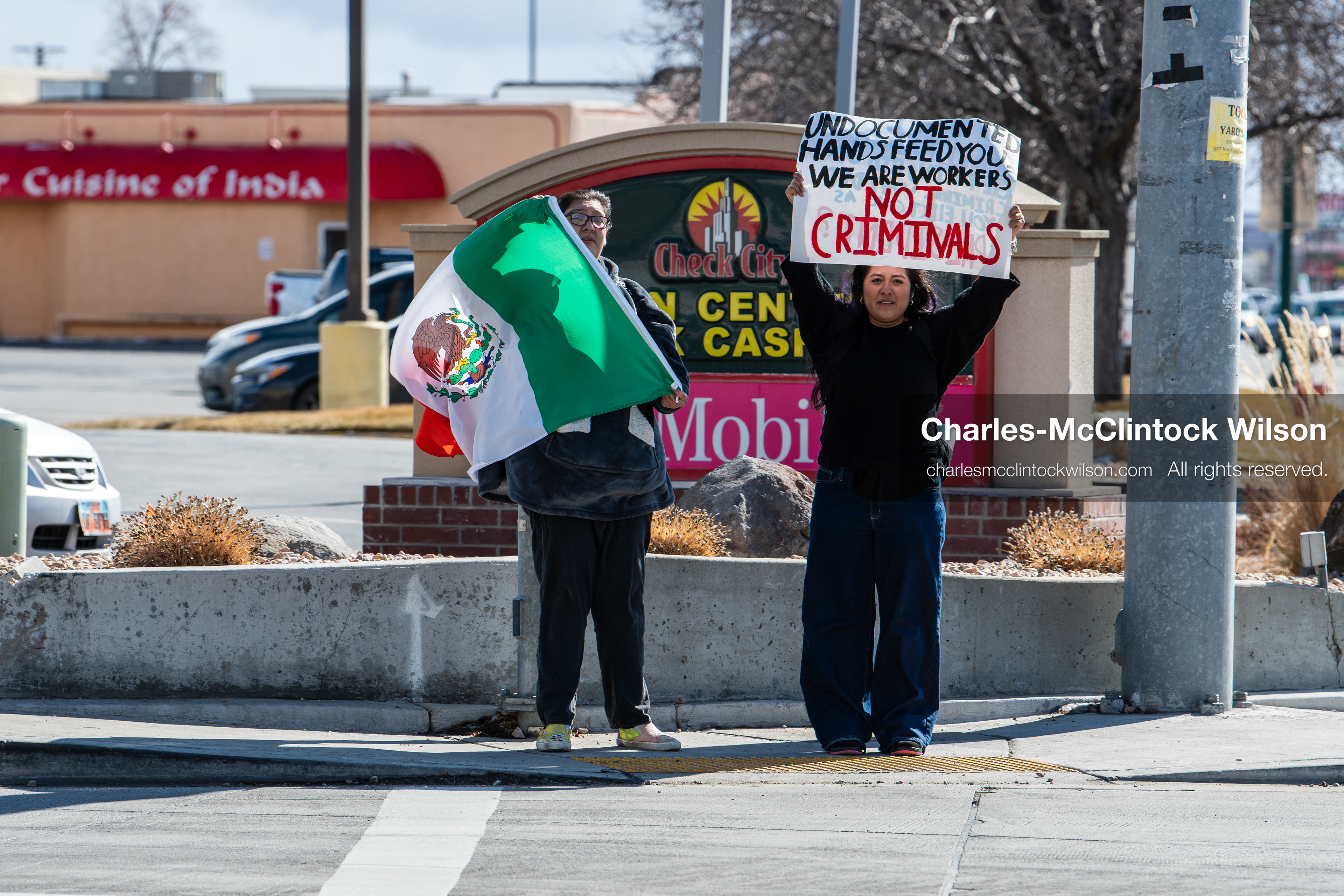February 20, 2026, Orem, Utah, USA: Participants stand at a street corner during a student led protest against ICE in front of Orem City Hall. One carries a flag while another holds a sign as vehicles pass through the area. (Credit Image: © Charles McClintock Wilson/ZUMA Press Wire)