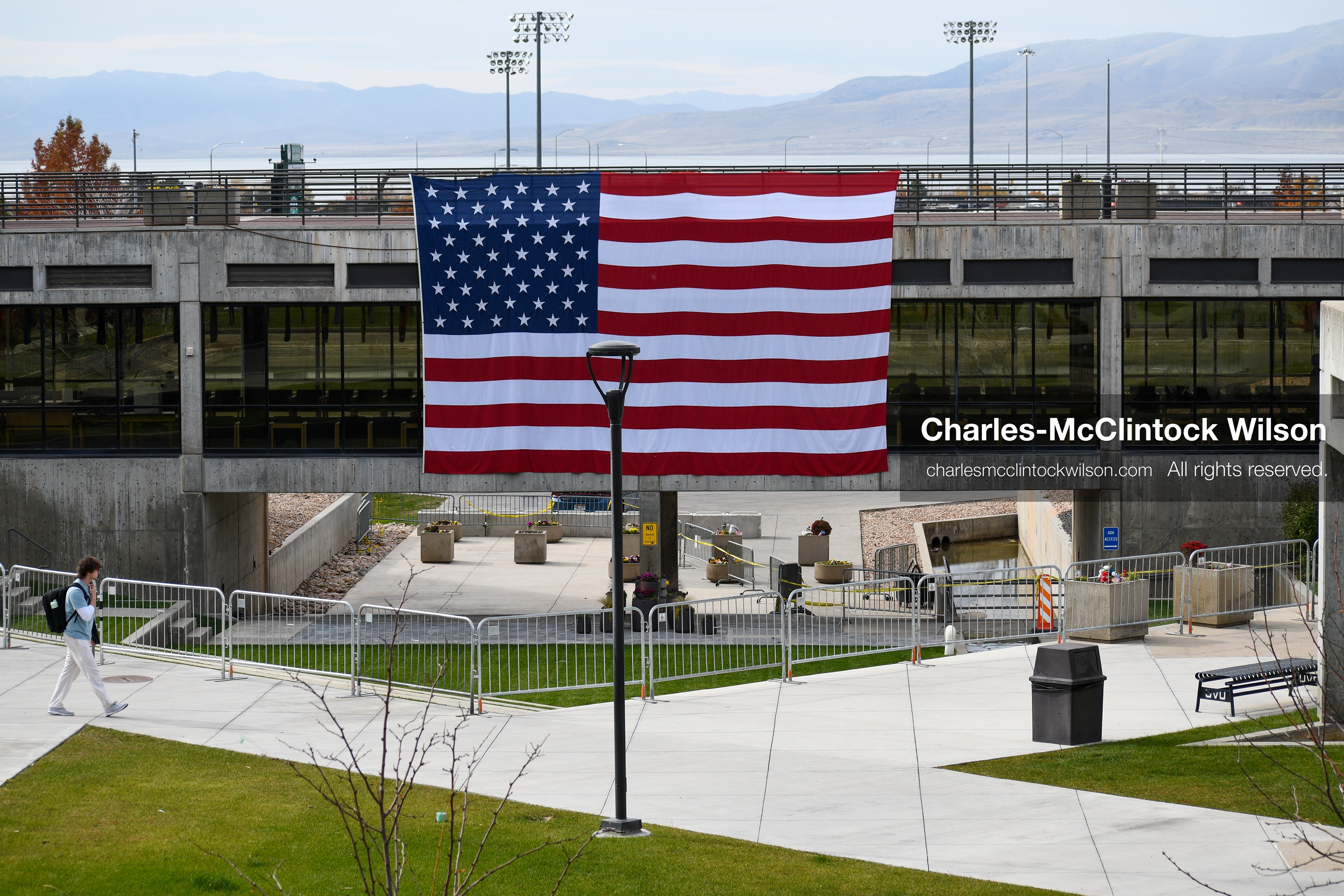 November 5, 2025, Orem, Utah, USA: A man walks by the site where conservative activist CHARLIE KIRK was shot and killed at Utah Valley University in Orem, Utah, on September 10, 2025, during a speaking event. A large U.S. flag is displayed above the courtyard on November 5, 2025. (Credit Image: © Charles-McClintock Wilson/ZUMA Press Wire)
