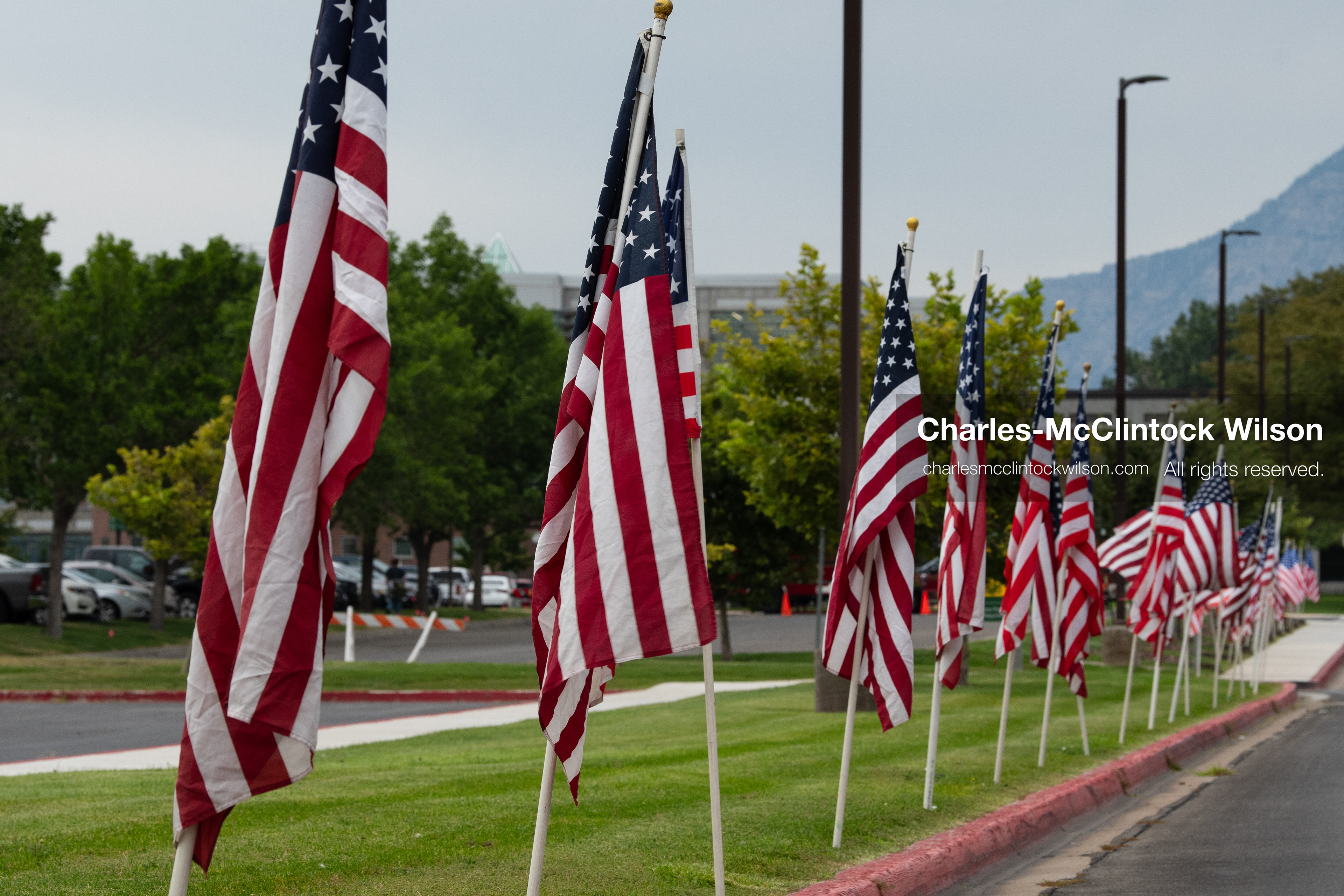 A long row of American flags lines the grassy perimeter outside the UCCU Center at Utah Valley University in Orem, Utah, on Wednesday, July 29, 2026. More than 300 people came to the public memorial ceremony to honor Provo Fire Captain Spencer Long, his wife Katrina, and three of their sons, who died after a flash flood hit their campsite near the Sunglow Campground in Wayne County. (Photo by Charles-McClintock Wilson/Sipa USA)