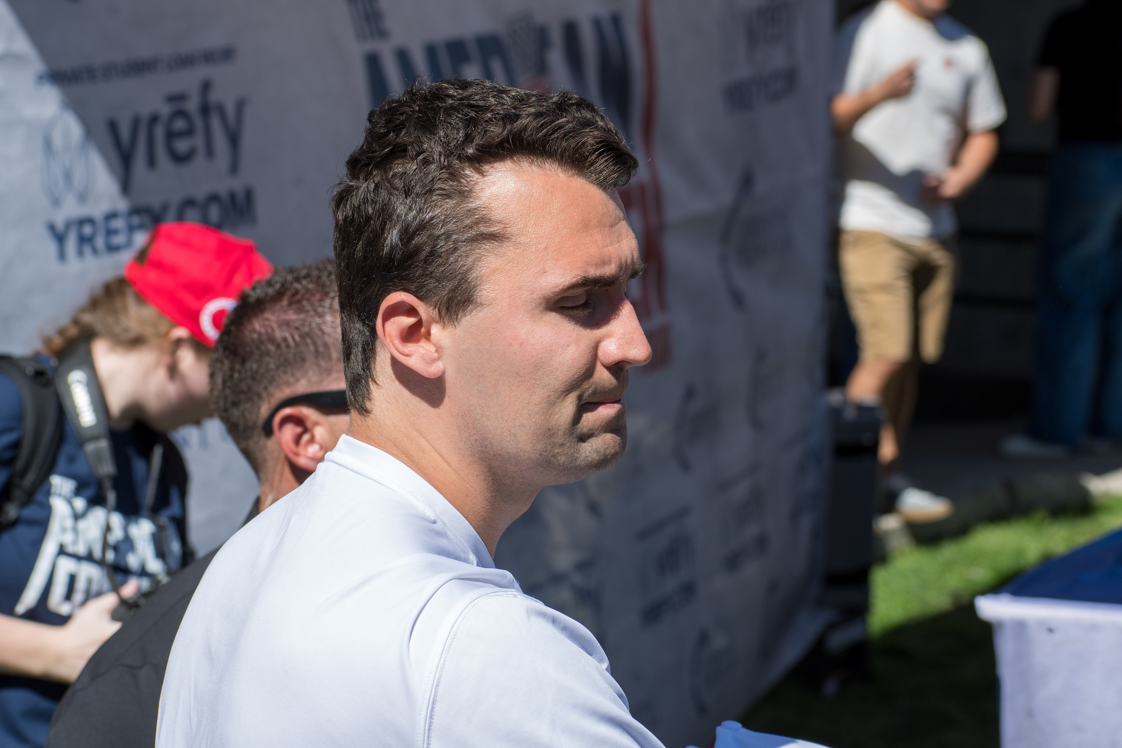 OREM, UTAH – SEPTEMBER 10, 2025: Charlie Kirk holds several “Make America Great Again” hats while interacting with supporters during a public event at Utah Valley University. Positioned near a merchandise table and surrounded by attendees, Kirk engages directly with the crowd in one of his final public moments. The image reflects the branding, outreach, and political symbolism that defined the gathering. © Charles-McClintock Wilson / ZUMA Press