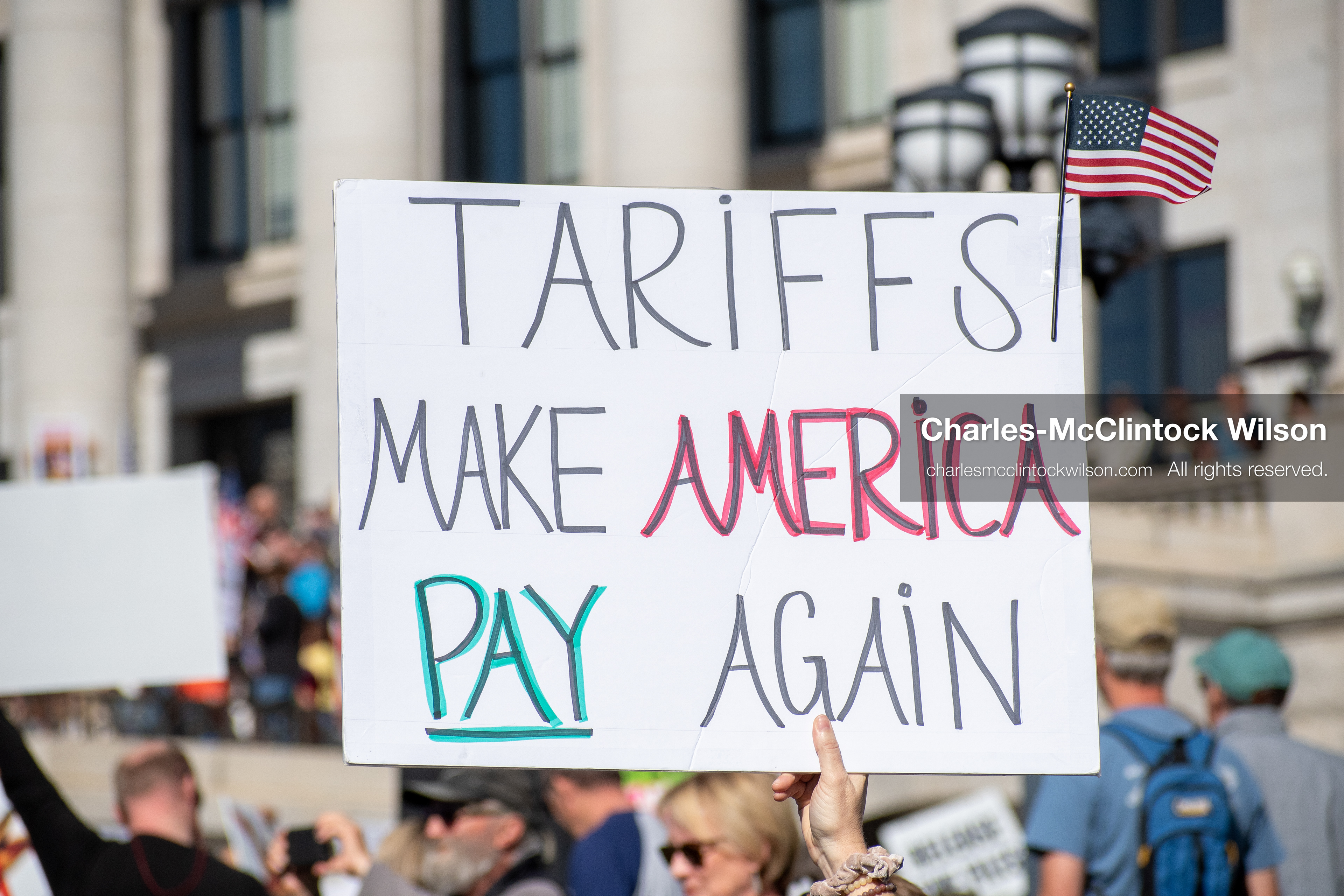 October 18, 2025, Salt Lake City, Utah, USA: A demonstrator raises a placard during a "No Kings" protest held at the Utah State Capitol. Other participants and signs are visible in the background during the public gathering.