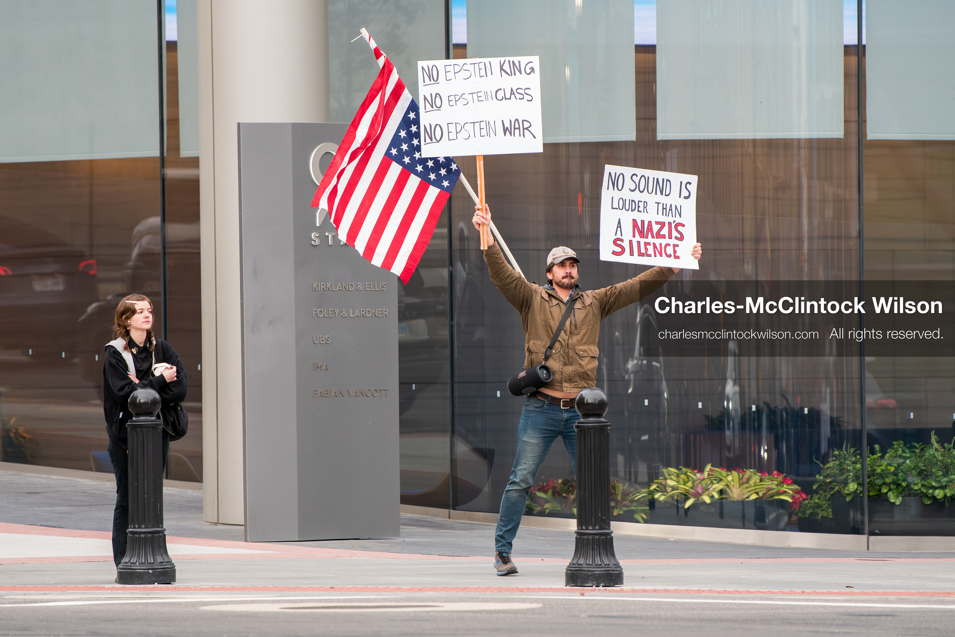 January 3, 2026, Salt Lake City, Utah, USA: A protester holds signs and an American flag during a demonstration against US action in Venezuela outside the Wallace Federal Building in Salt Lake City, Utah. The protest was part of a nationwide mobilization responding to recent military developments. (Credit Image: (c) Charles‑McClintock Wilson/ZUMA Press Wire)