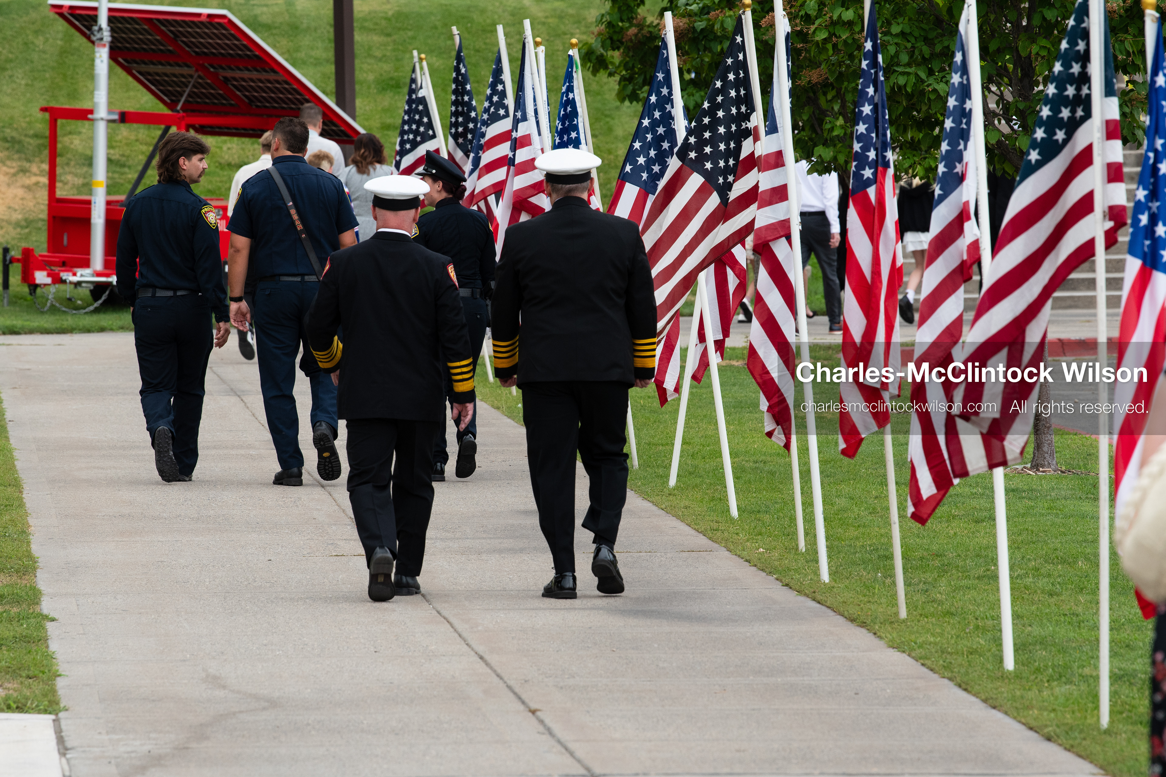 Attendees walk along a sidewalk lined with American flags toward the entrance of the UCCU Center on the campus of Utah Valley University in Orem, Utah, on Wednesday, July 29, 2026. More than 300 people came to the public memorial ceremony to honor Provo Fire Captain Spencer Long, his wife Katrina, and three of their sons, who died after a flash flood hit their campsite near the Sunglow Campground in Wayne County. (Photo by Charles-McClintock Wilson/Sipa USA)