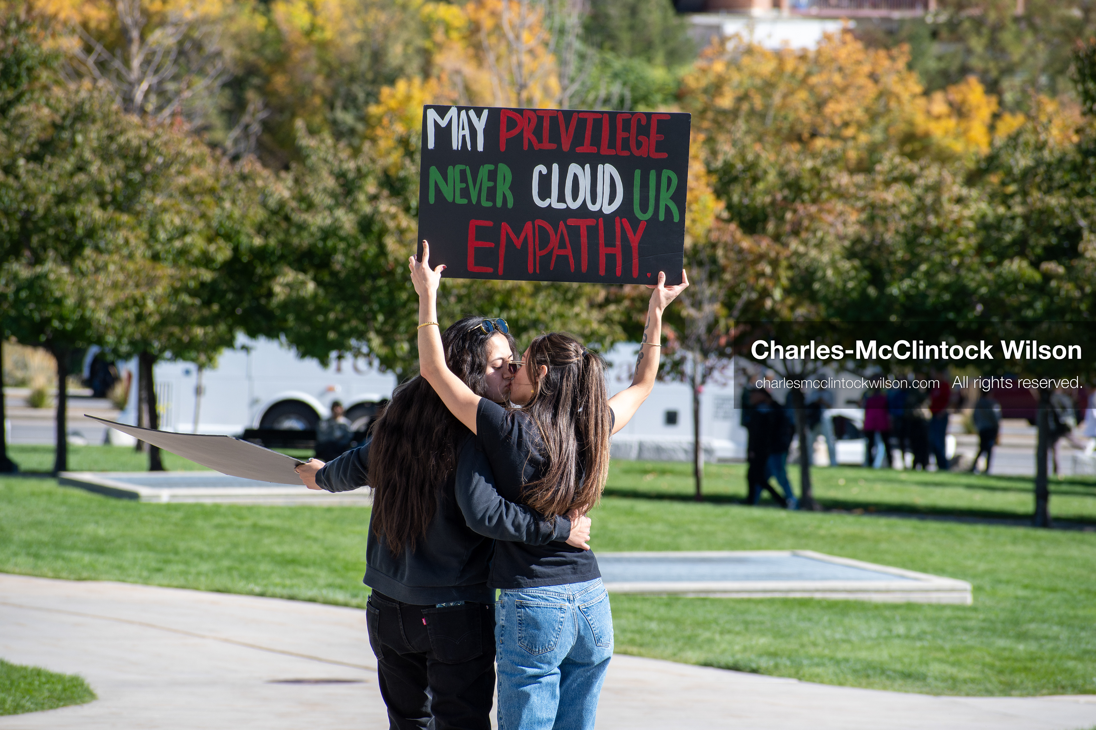 October 18, 2025, Salt Lake City, Utah, USA: Two demonstrators embrace during a "No Kings" protest at the Utah State Capitol in Salt Lake City, Utah. One holds a sign overhead as part of the nationwide mobilization.