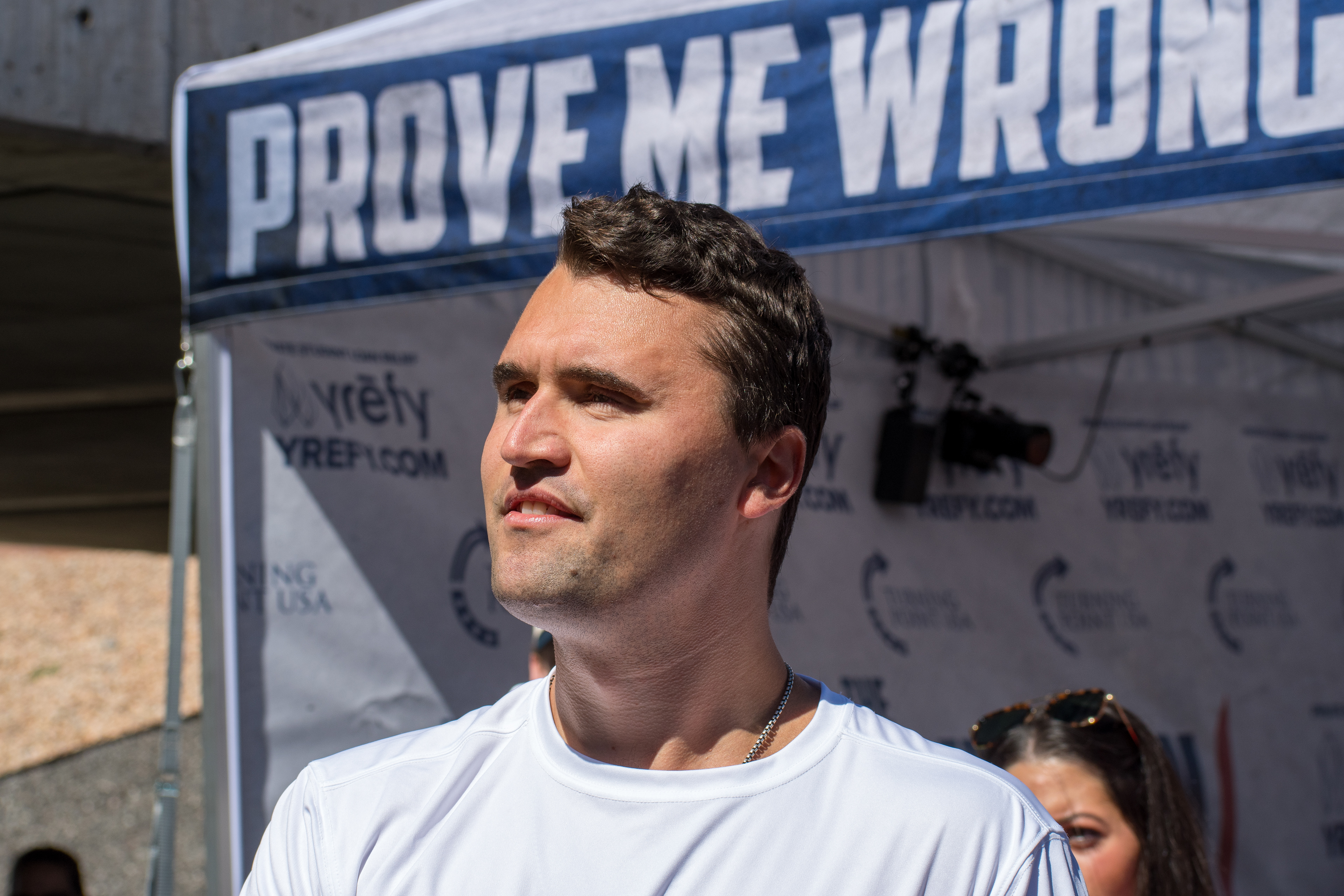 OREM, UTAH – SEPTEMBER 10, 2025: Charlie Kirk speaks with attendees during a public event at Utah Valley University. Positioned near a promotional booth and surrounded by supporters, Kirk appears engaged and expressive in one of his final public moments. The image reflects the atmosphere of direct outreach and energized dialogue that defined the gathering. © Charles-McClintock Wilson / ZUMA Press