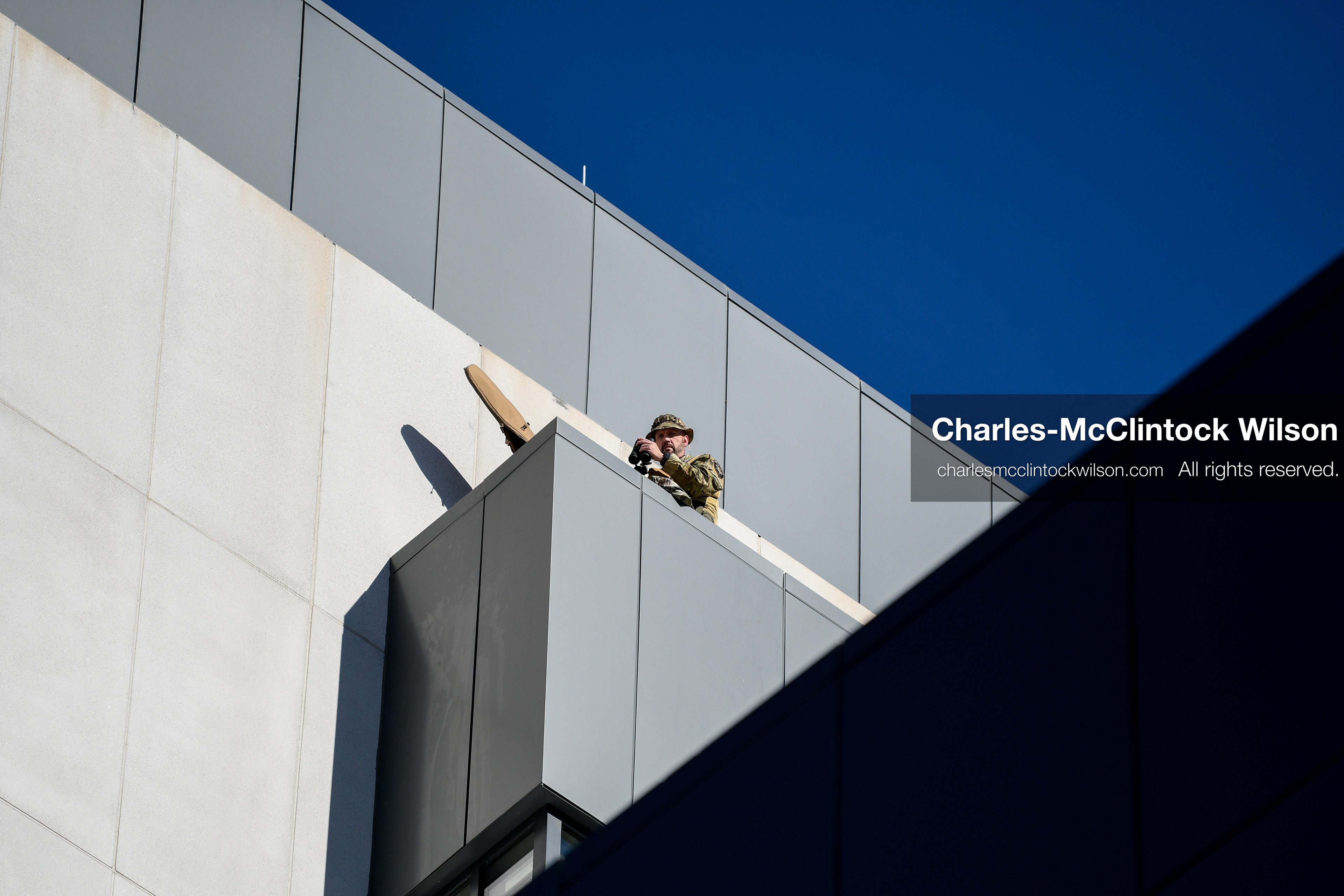 PROVO, UTAH, USA – DECEMBER 11, 2025: A SWAT officer monitors the scene from the roof of the Fourth District Court in Provo during the first in‑person court appearance of Tyler Robinson in the Charlie Kirk murder case. (Credit Image: © Charles‑McClintock Wilson/ZUMA Press Wire)