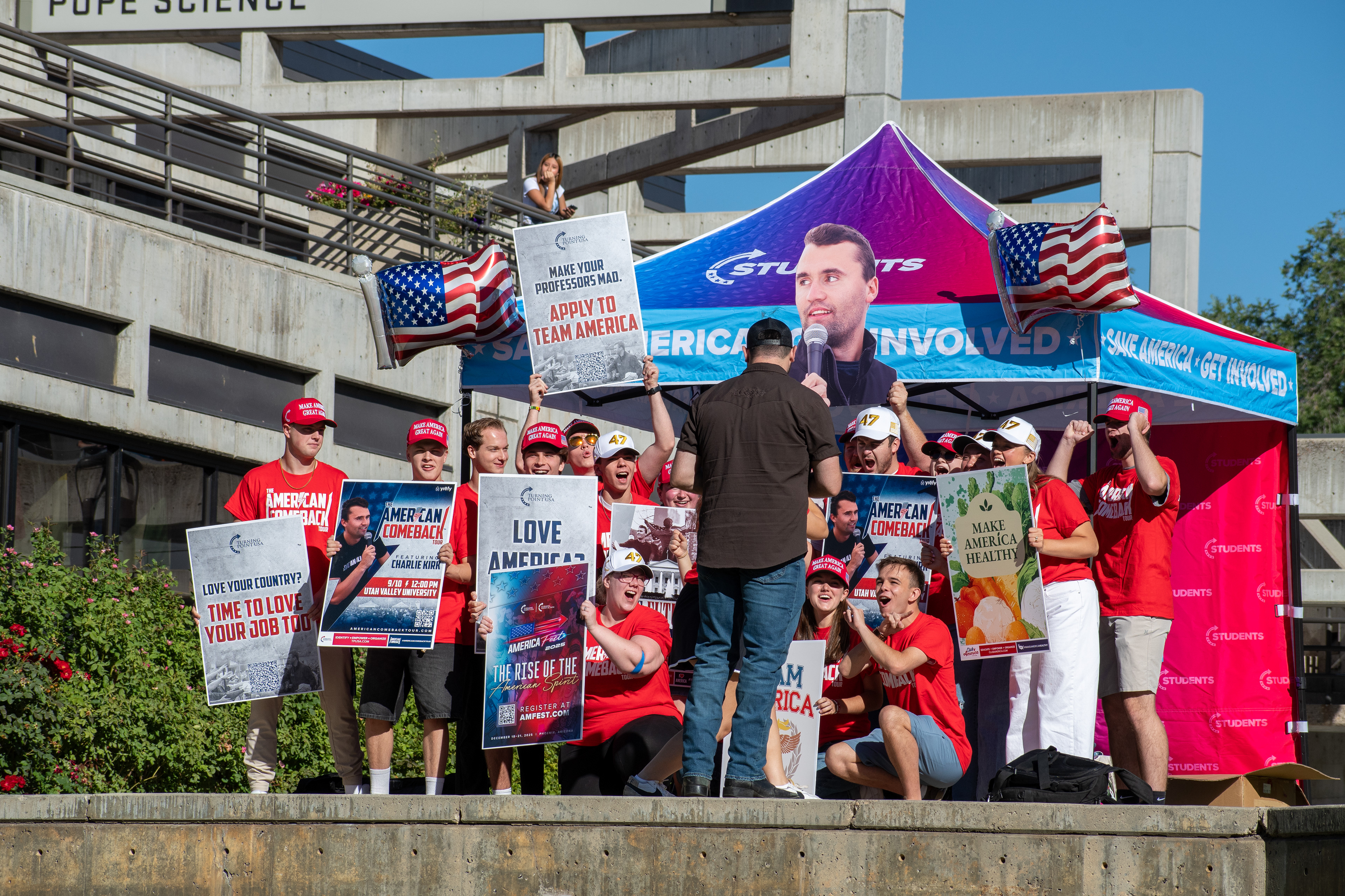 OREM, UTAH – SEPTEMBER 10, 2025: Attendees gather outside the Pope Science building at Utah Valley University during the opening stop of the American Comeback Tour. Surrounded by signage and coordinated attire, the group reflects a moment of thematic clarity, civic invitation, and communal energy. The image captures the rhythm of participation and the visual texture that shaped the event’s atmosphere. © Charles-McClintock Wilson / ZUMA Press