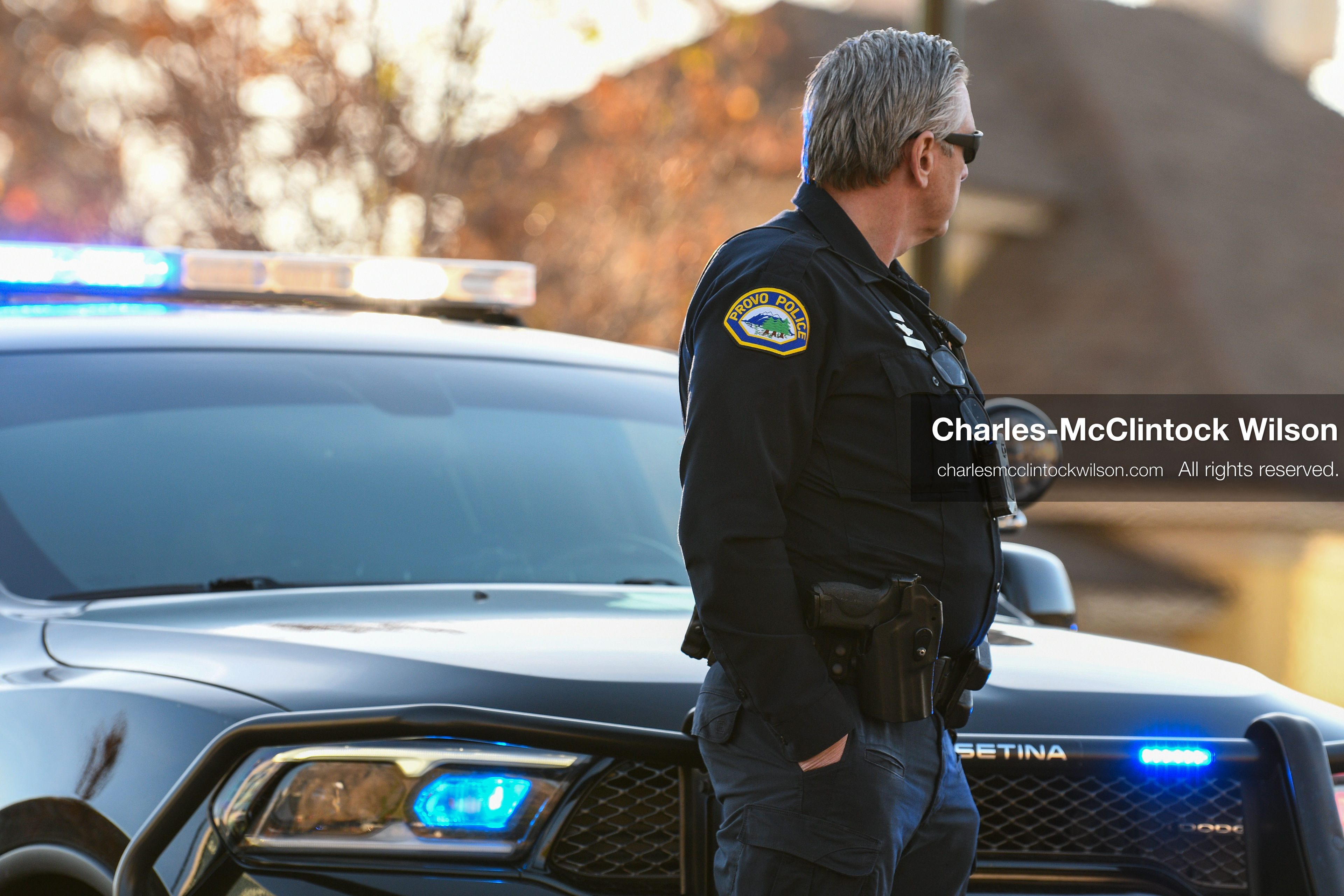 PROVO, UTAH, USA – DECEMBER 11, 2025: A Provo Police officer stands beside a patrol vehicle in a residential neighborhood near the Fourth District Court in Provo during the first in‑person court appearance of Tyler Robinson in the Charlie Kirk murder case. (Credit Image: © Charles‑McClintock Wilson/ZUMA Press Wire)