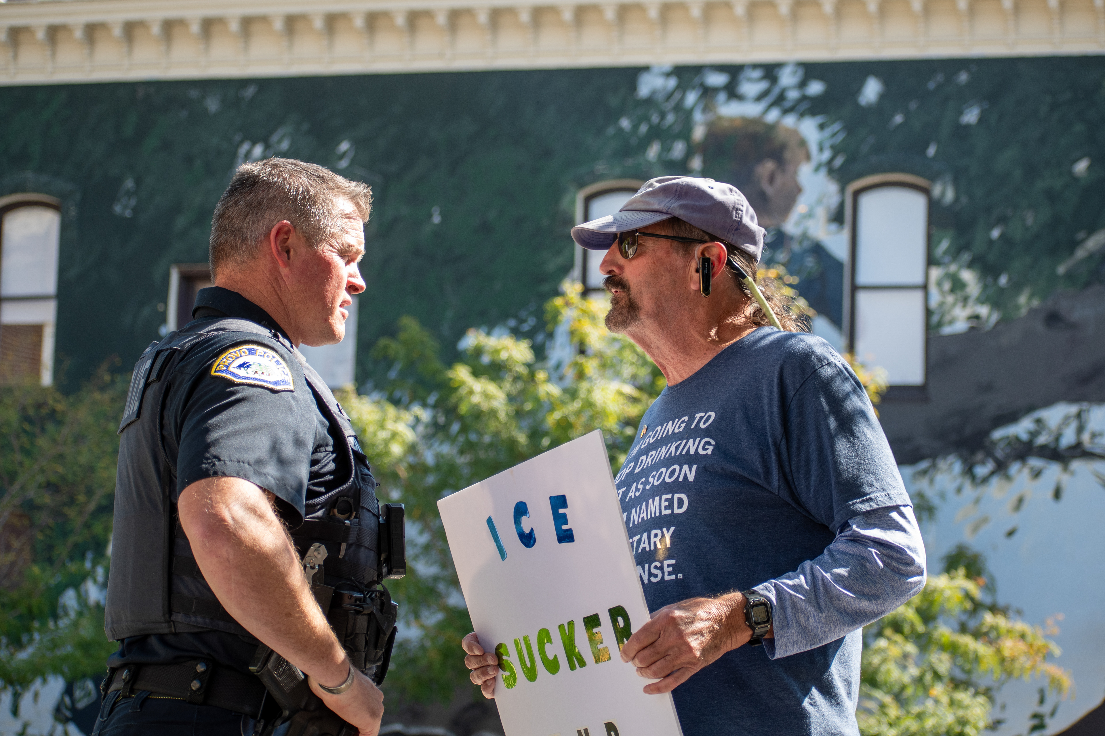 September 15, 2025 – Provo, Utah, United States: A demonstrator engages with a police officer outside the Utah Valley Convention Center during a protest against the Department of Homeland Security career expo. The individual holds a partially visible sign referencing ICE, while the exchange highlights the tension between civic dissent and law enforcement presence. Photograph by Charles‑McClintock Wilson / ZUMA Press Wire