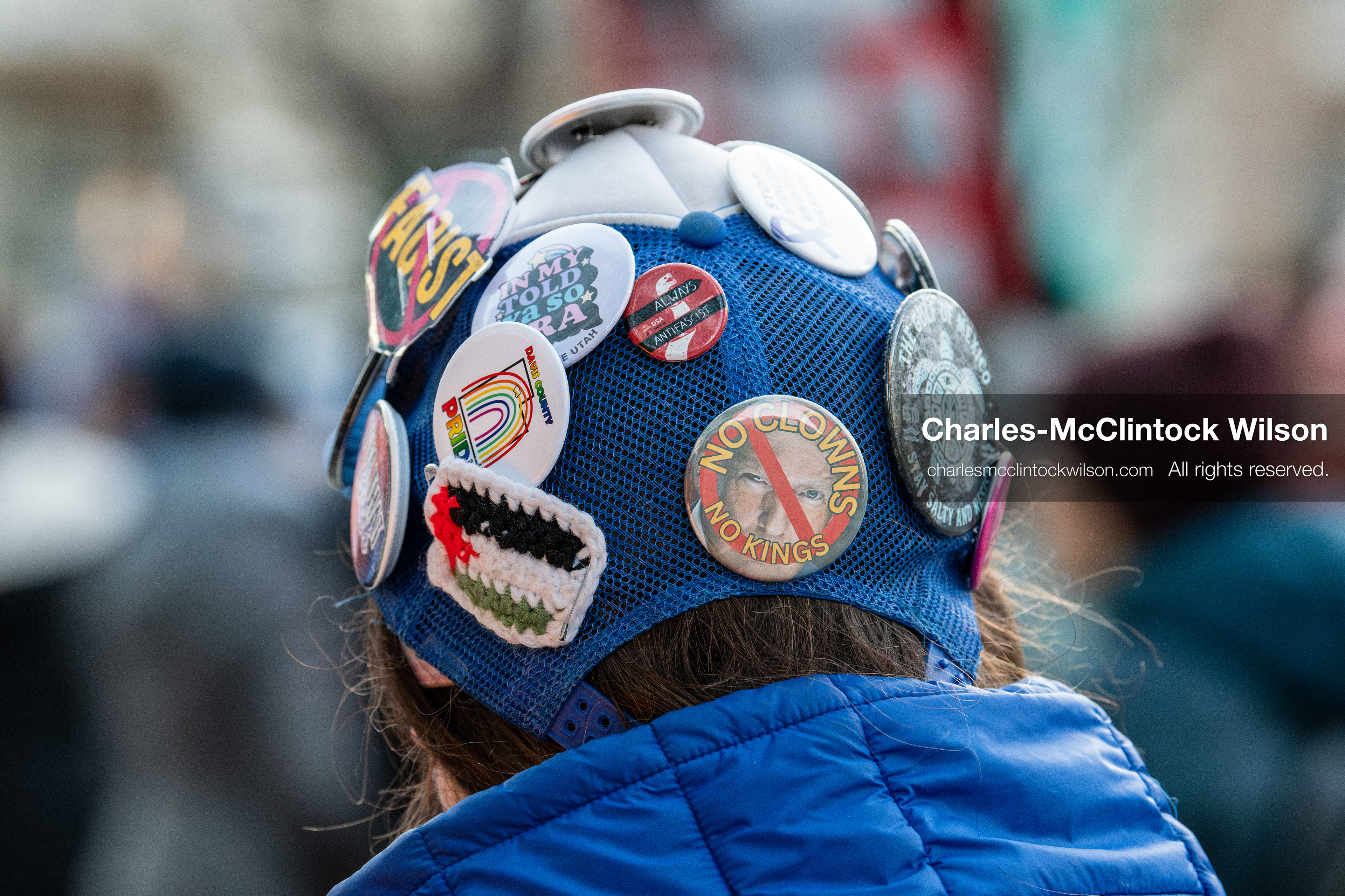 January 5, 2026, Salt Lake City, Utah, USA: A demonstrator wearing a blue cap adorned with colorful pins attends a protest outside the Wallace Federal Building in Salt Lake City, Utah. The rally, organized by Salt Lake Indivisible, called for congressional limits on presidential war powers following recent US military actions in Venezuela involving the government of Nicolas Maduro. Attendees signed petitions addressed to Utah US senators Mike Lee and John Curtis. (Credit Image: (c) Charles‑McClintock Wilson/ZUMA Press Wire)