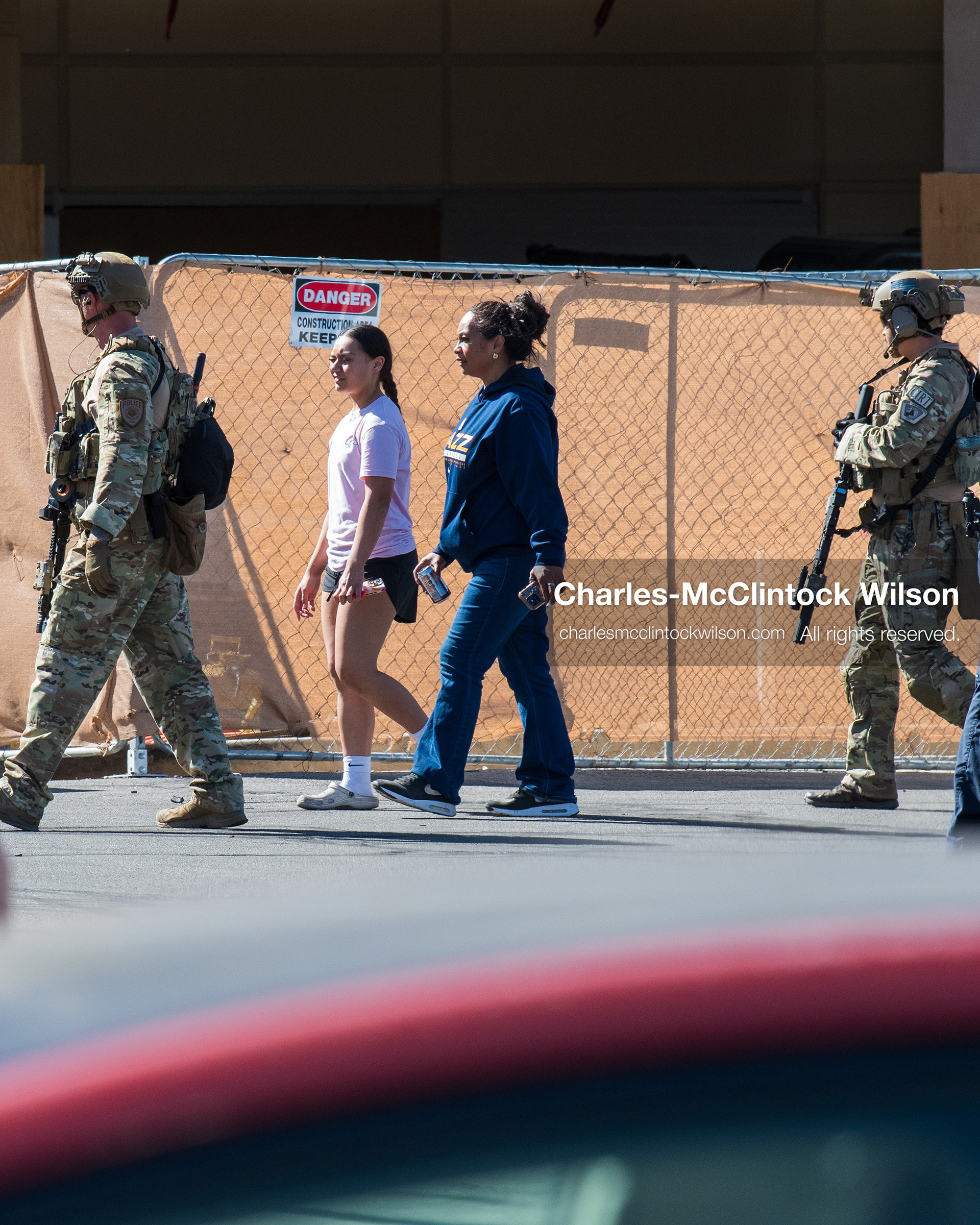 August 17, 2026, Murray, Utah, USA: Armed law enforcement officers in tactical gear escort two civilians past a construction barrier outside Intermountain Medical Center in Murray, Utah, on Monday. Multiple police agencies secured the hospital perimeter as a safety precaution after shooting victims were brought in from a fatal shootout outside a funeral in nearby Kearns. (Credit Image: © Charles McClintock Wilson/ZUMA Press Wire)