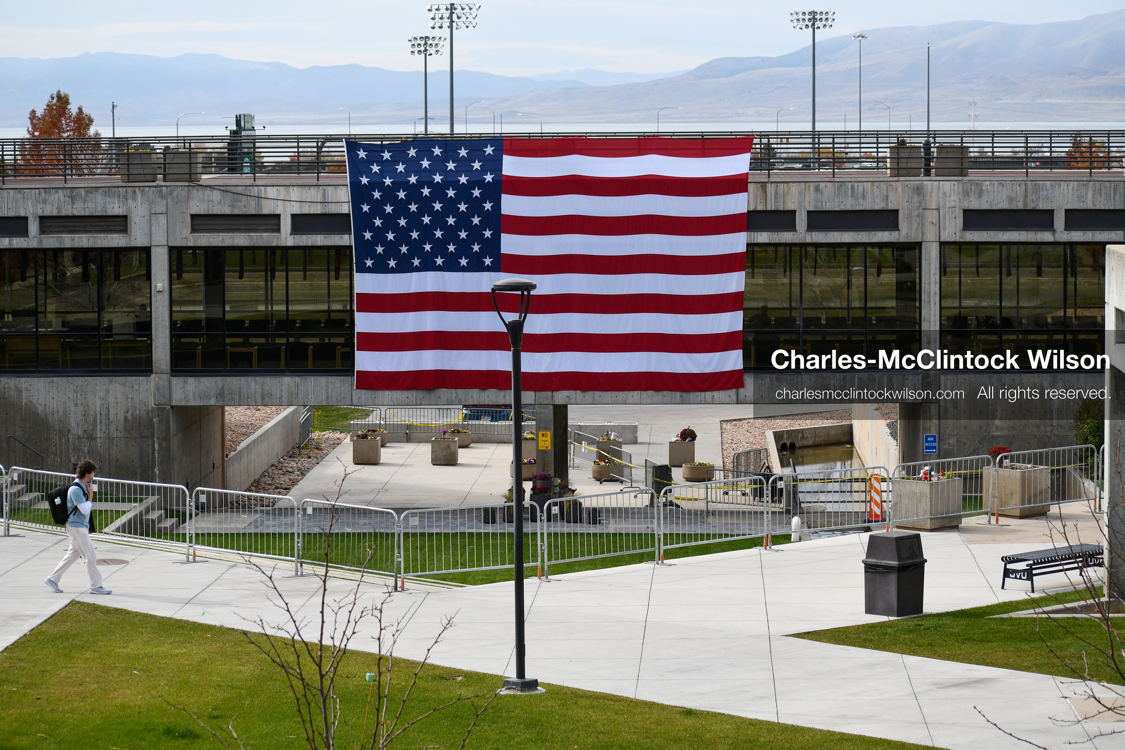 November 5, 2025, Orem, Utah, USA: A man walks by the site where conservative activist CHARLIE KIRK was shot and killed at Utah Valley University in Orem, Utah, on September 10, 2025, during a speaking event. A large U.S. flag is displayed above the courtyard on November 5, 2025. (Credit Image: © Charles-McClintock Wilson/ZUMA Press Wire)