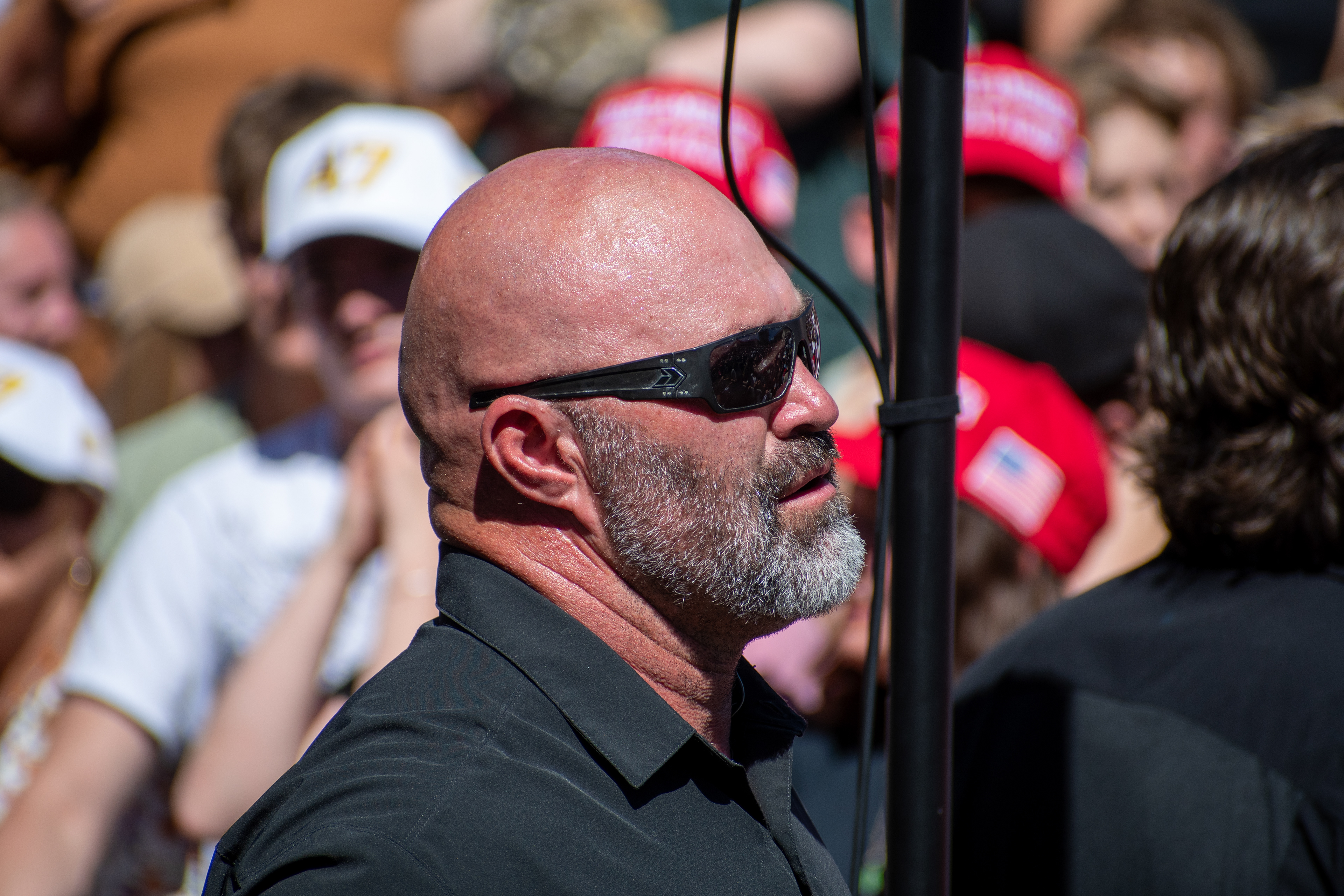 OREM, UTAH – SEPTEMBER 10, 2025: A security detail stands near the perimeter at Utah Valley University during the opening stop of the American Comeback Tour. Positioned beside the crowd, the individual reflects the quiet vigilance and logistical coordination that shaped the event’s atmosphere. The image captures a moment of presence, contrast, and civic anticipation. © Charles-McClintock Wilson / ZUMA Press