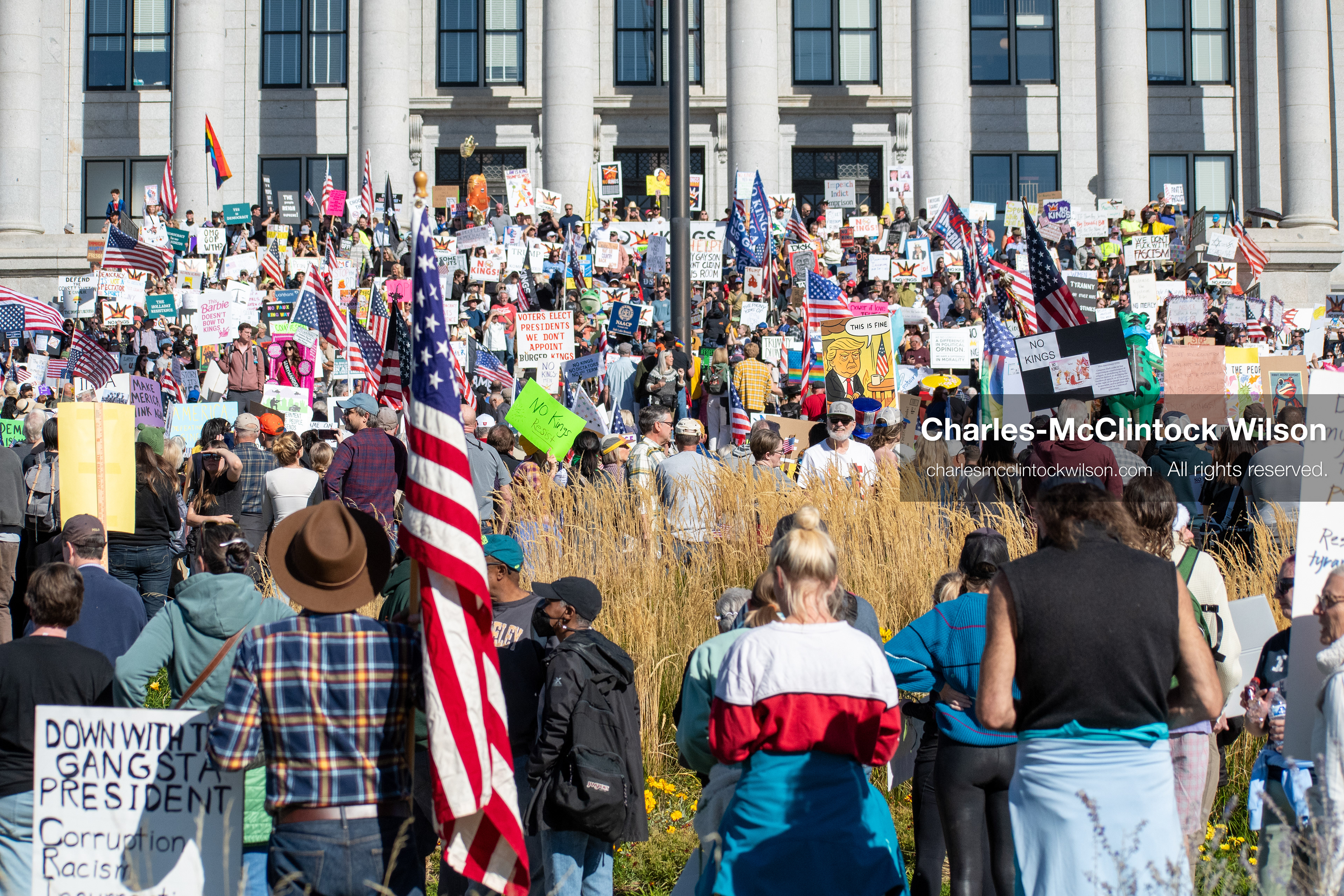 October 18, 2025, Salt Lake City, Utah, USA: Demonstrators gather on the steps of the Utah State Capitol during a "No Kings" protest held as part of a nationwide mobilization. Participants hold signs and flags while documenting the event. The protest was one of several organized across the United States.